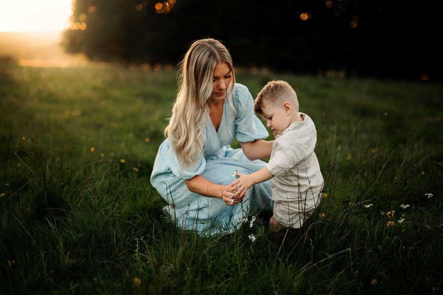 Intimate outdoor moment shared in a meadow during sunset hours.