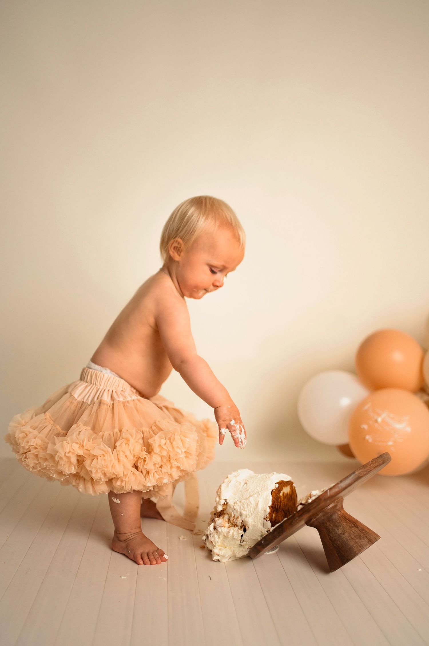 Flicka på sin smash the cake fotografering hos Lovestories By Sara. Flickan har på sig en beige tyllkjol.