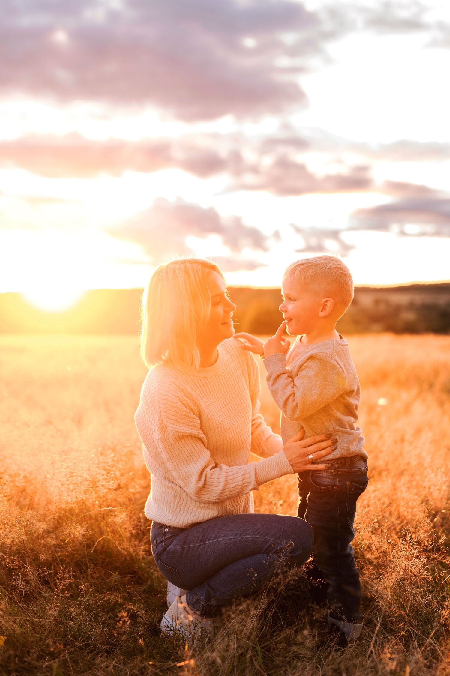 Intimate portrait of parent and child sharing a special moment in warm evening sunlight.