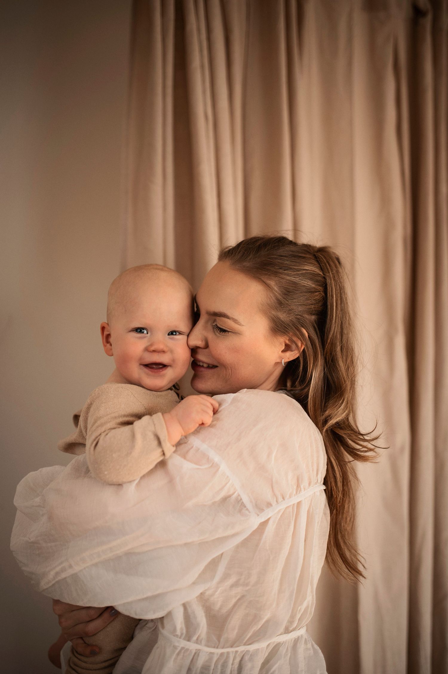 A parent in a white shirt embraces and kisses a laughing baby in a heartwarming sequence of candid moments.
