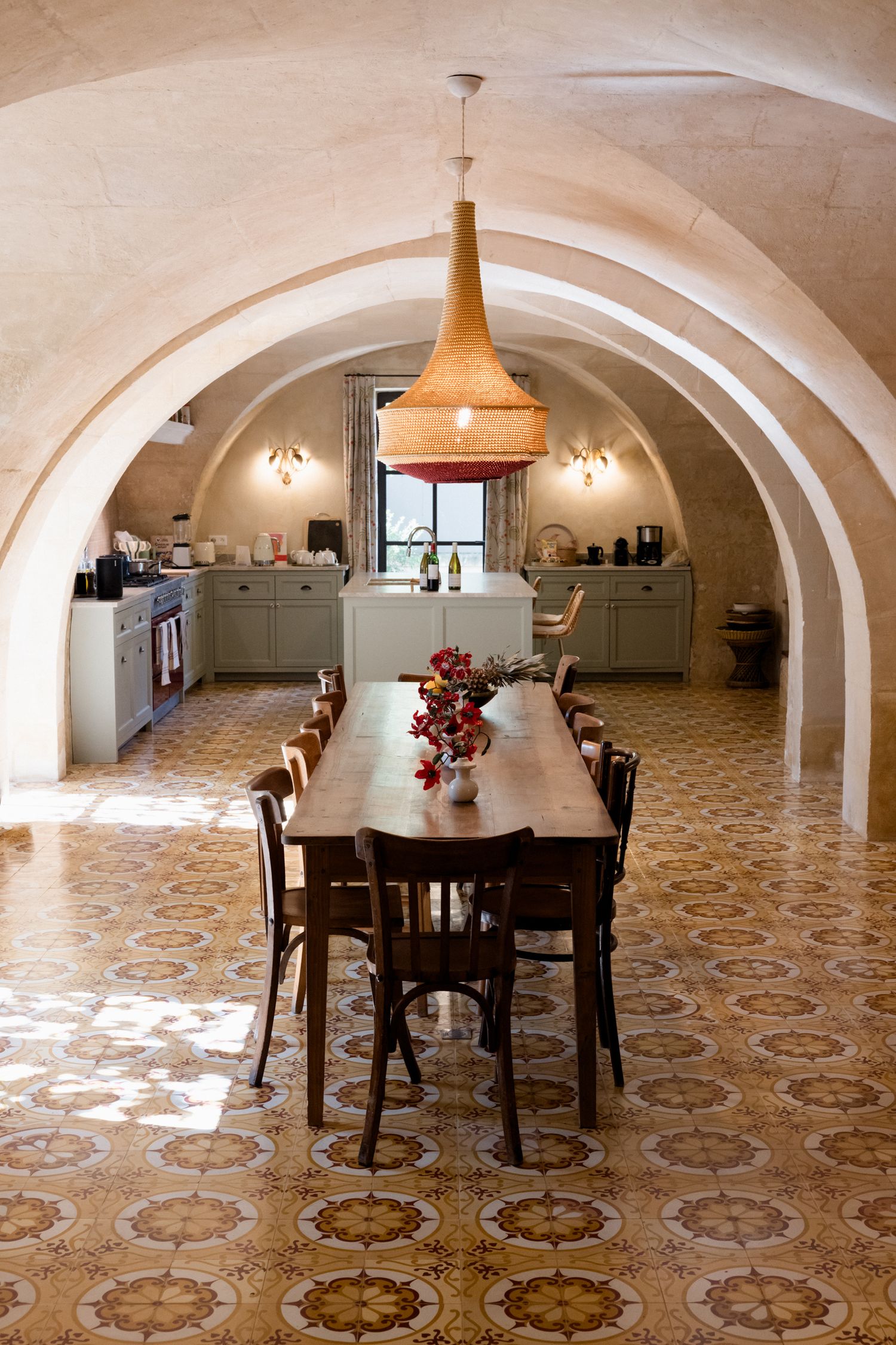 Panoramic view of a vaulted basement dining room with patterned tile floors and pendant lighting fixtures. Saint Remy de Provence