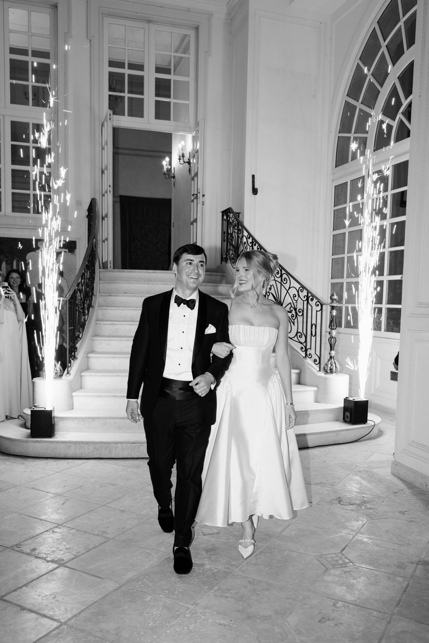 Black and white photos show wedding newlyweds walking through an elegant venue with arched windows. Editorial wedding photographer france