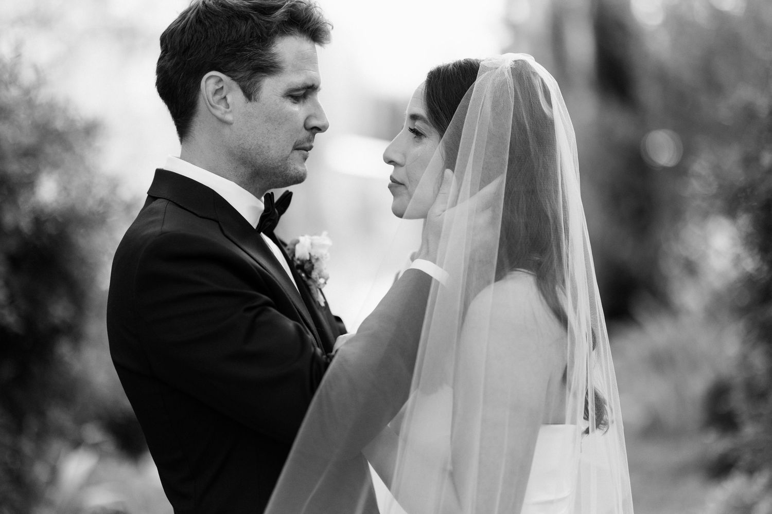 A series of romantic black and white wedding photos showing intimate moments between newlyweds outdoors.
