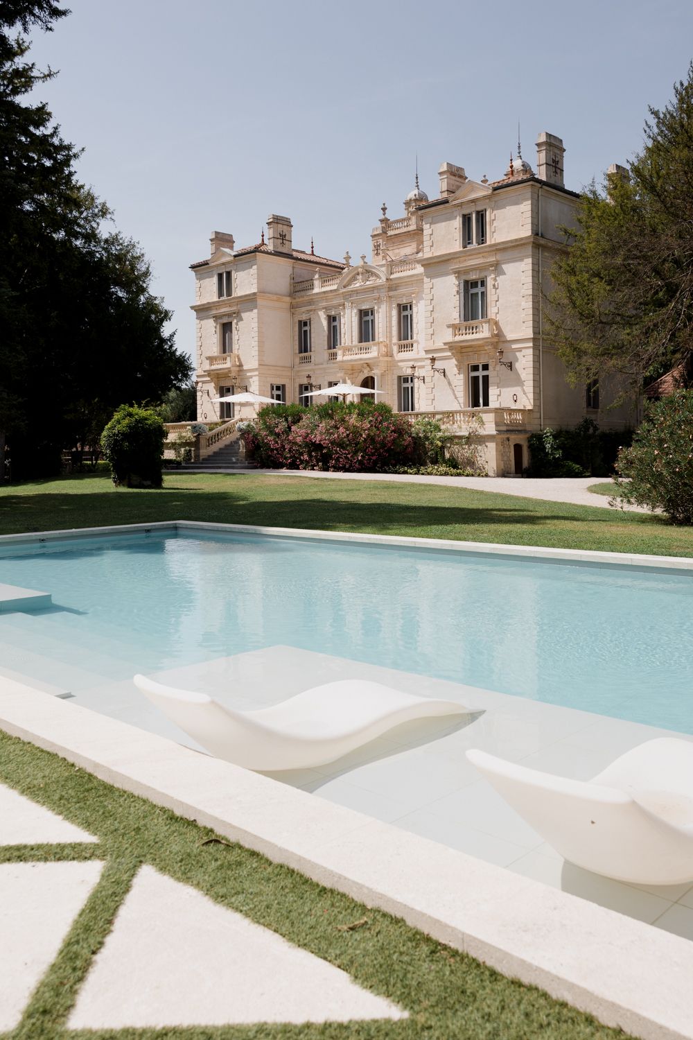 Multiple views of an elegant stone mansion with swimming pool showing modern amenities and manicured grounds. Château des trois Fontaines