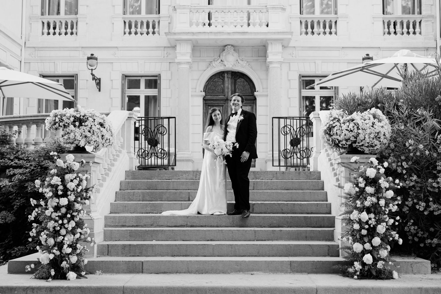 A sequence of black and white wedding photos showing outdoor ceremony scenes with floral decorations and grand staircases.