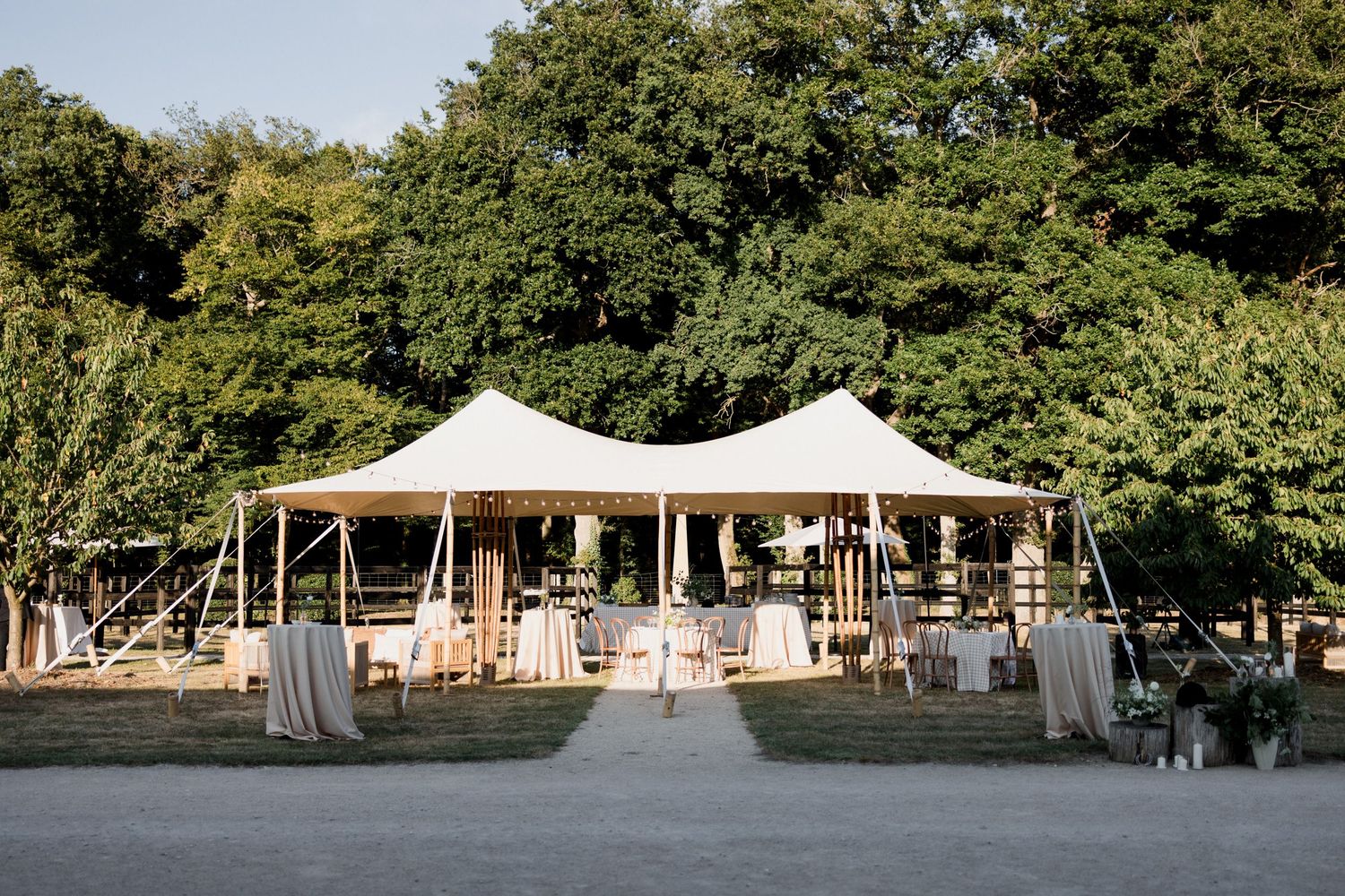 A row of elegant white glamping tents set up in a wooded area for luxury outdoor accommodations. Loire valley wedding photographer