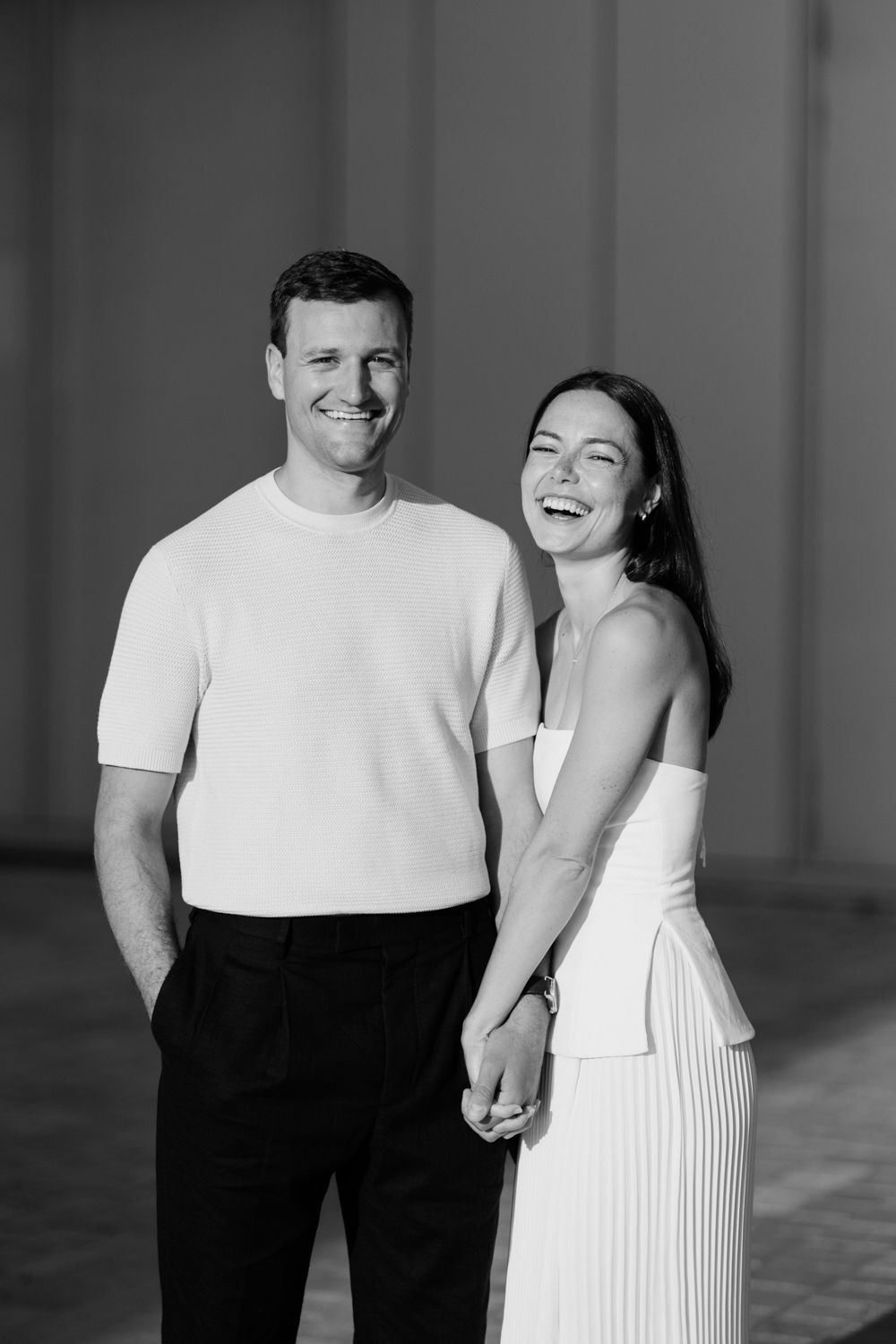 Couple laughing together in black and white photo wearing contrasting outfits. Photographe couple Tours