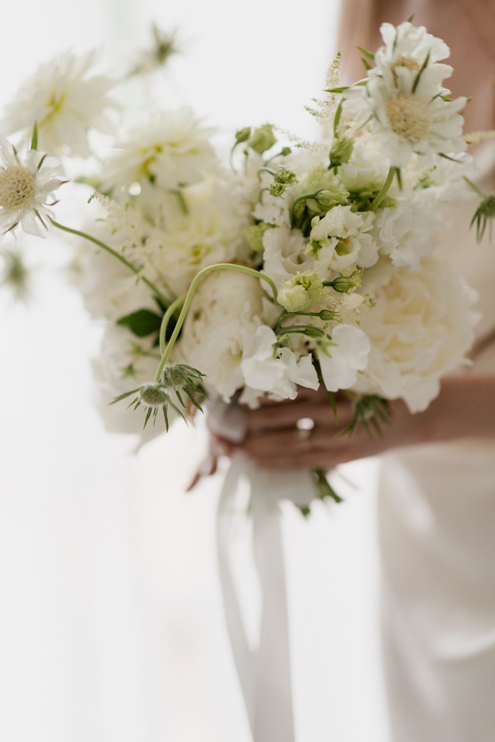 Small white flower arrangements in glass vases create an elegant wedding table centerpiece display.