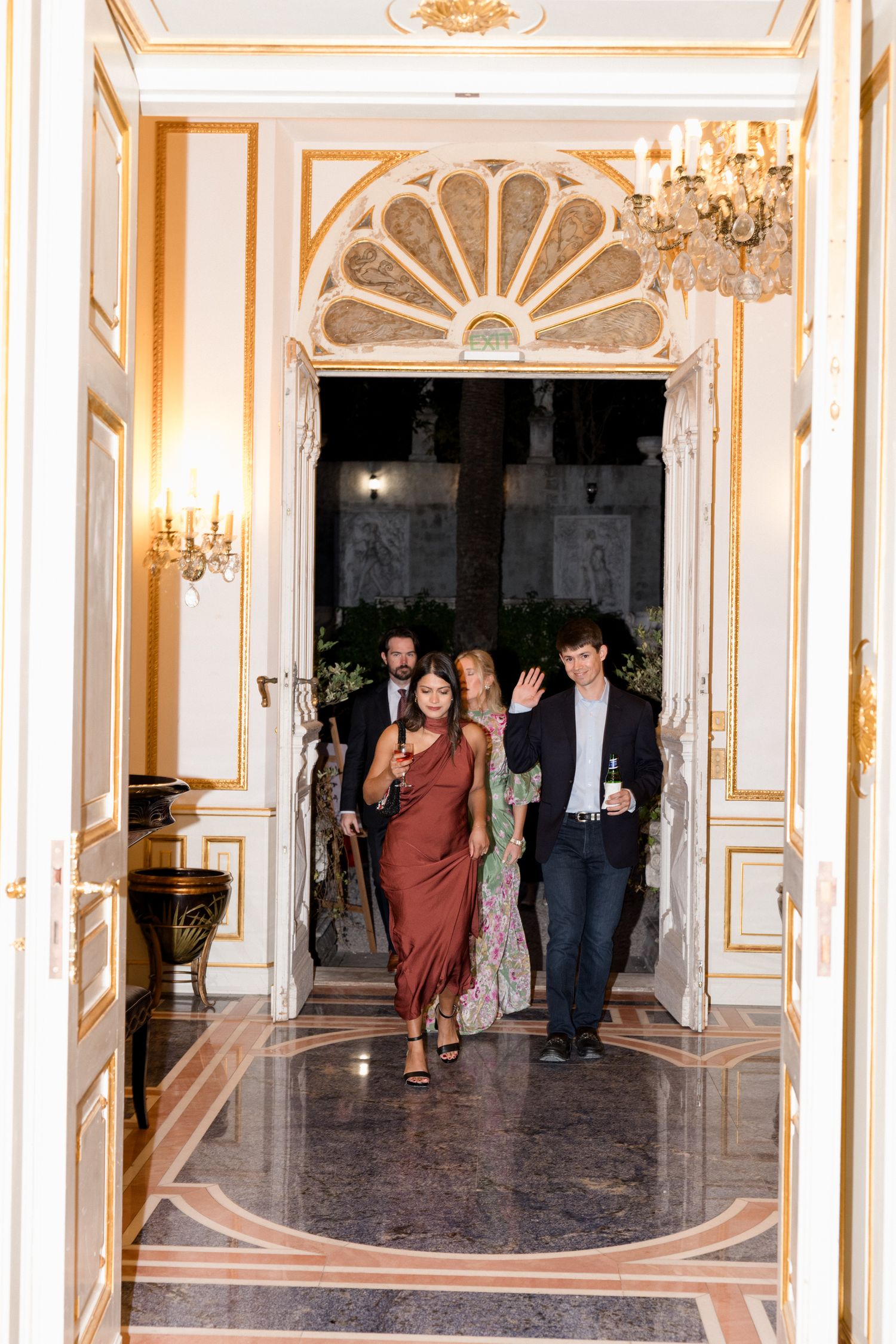 Elegant hallway with ornate gold trim, crystal chandeliers and marble floors in a luxurious historic palace interior.