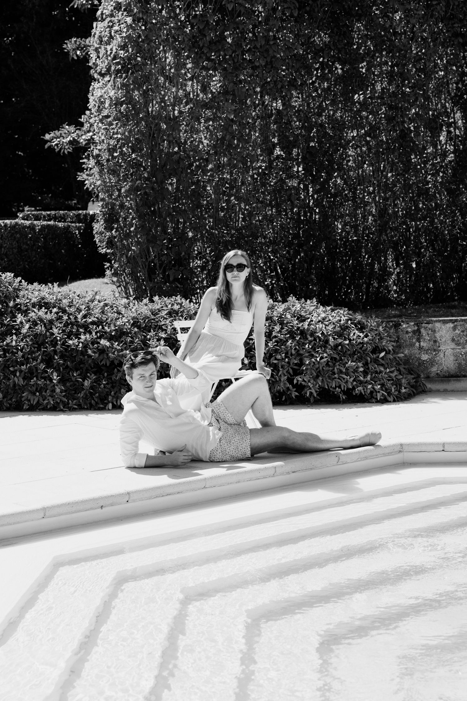 A black and white photo series showing someone lounging and reading on the ground in a sunny outdoor setting. Editorial brunch