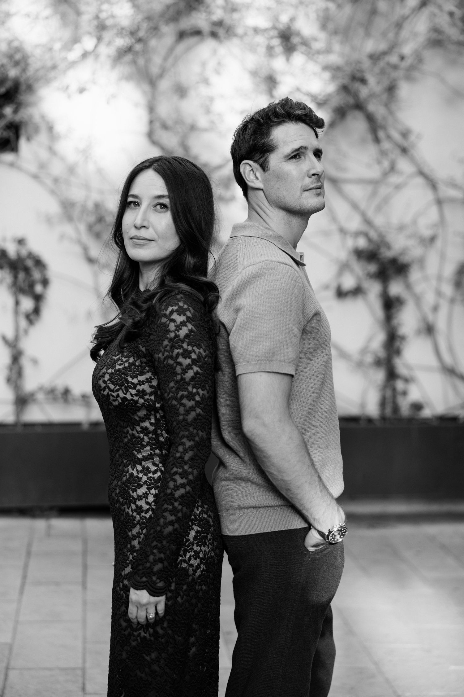 Stylish couple in black and white photo standing back to back in urban setting. Saint Remy de Provence