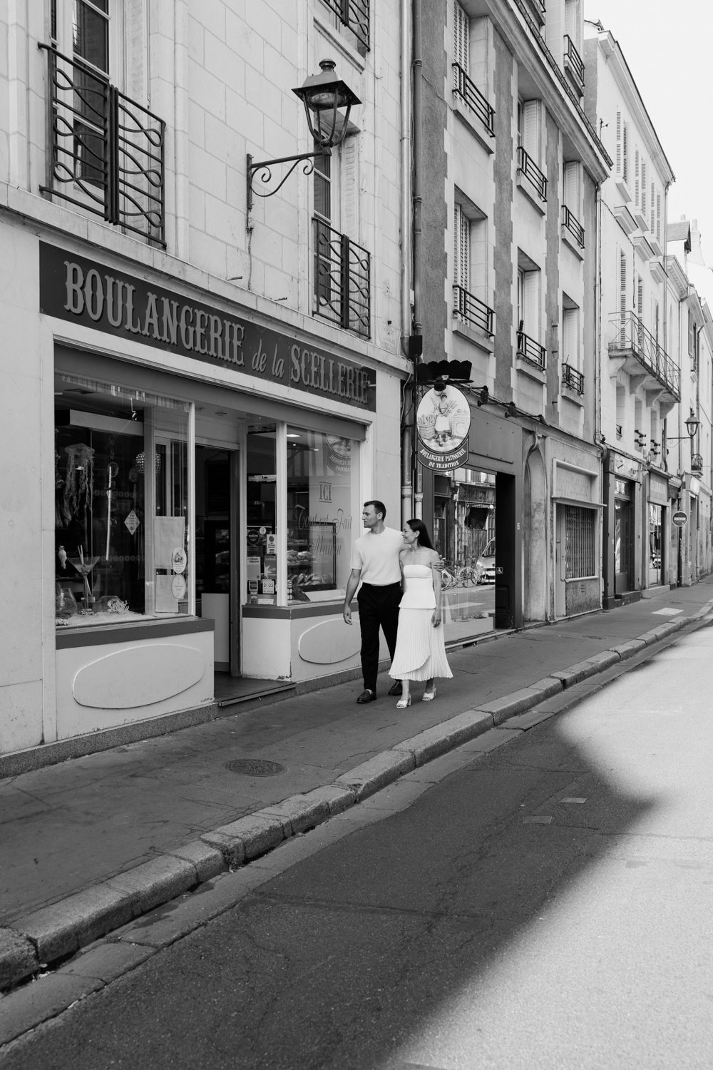A sequence of black and white photos showing a quiet street with a boulangerie storefront and people walking.