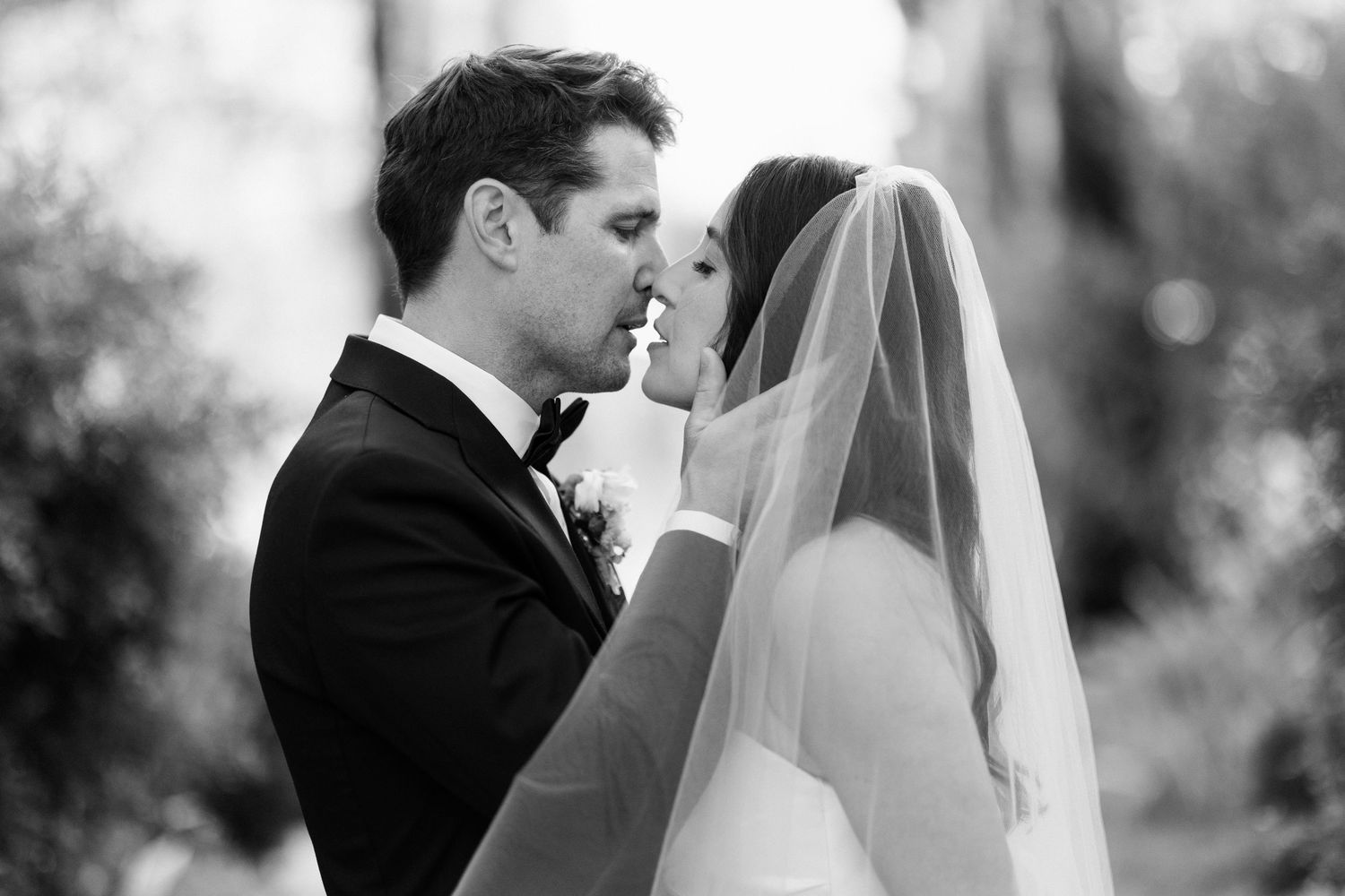 Black and white wedding photo series showing romantic moments between a bride and groom in formal attire.