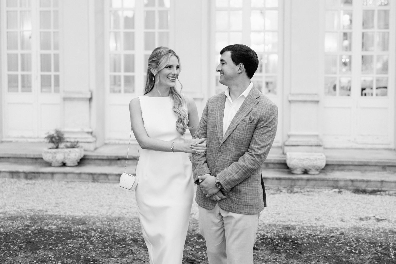 A joyful couple shares a candid moment together outdoors in black and white photography.