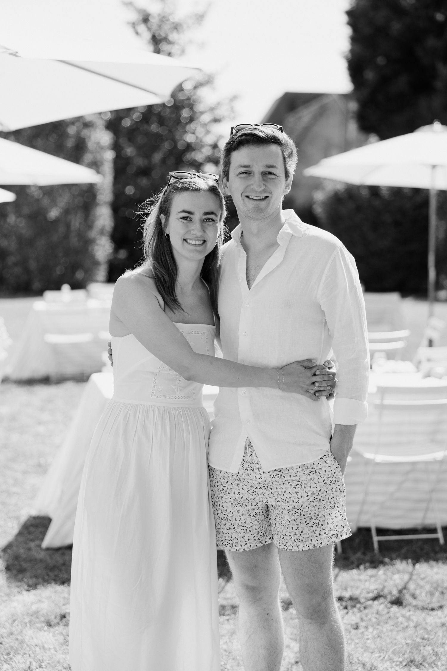 A couple in white summer outfits embracing outdoors in black and white photography. Paris wedding photographer