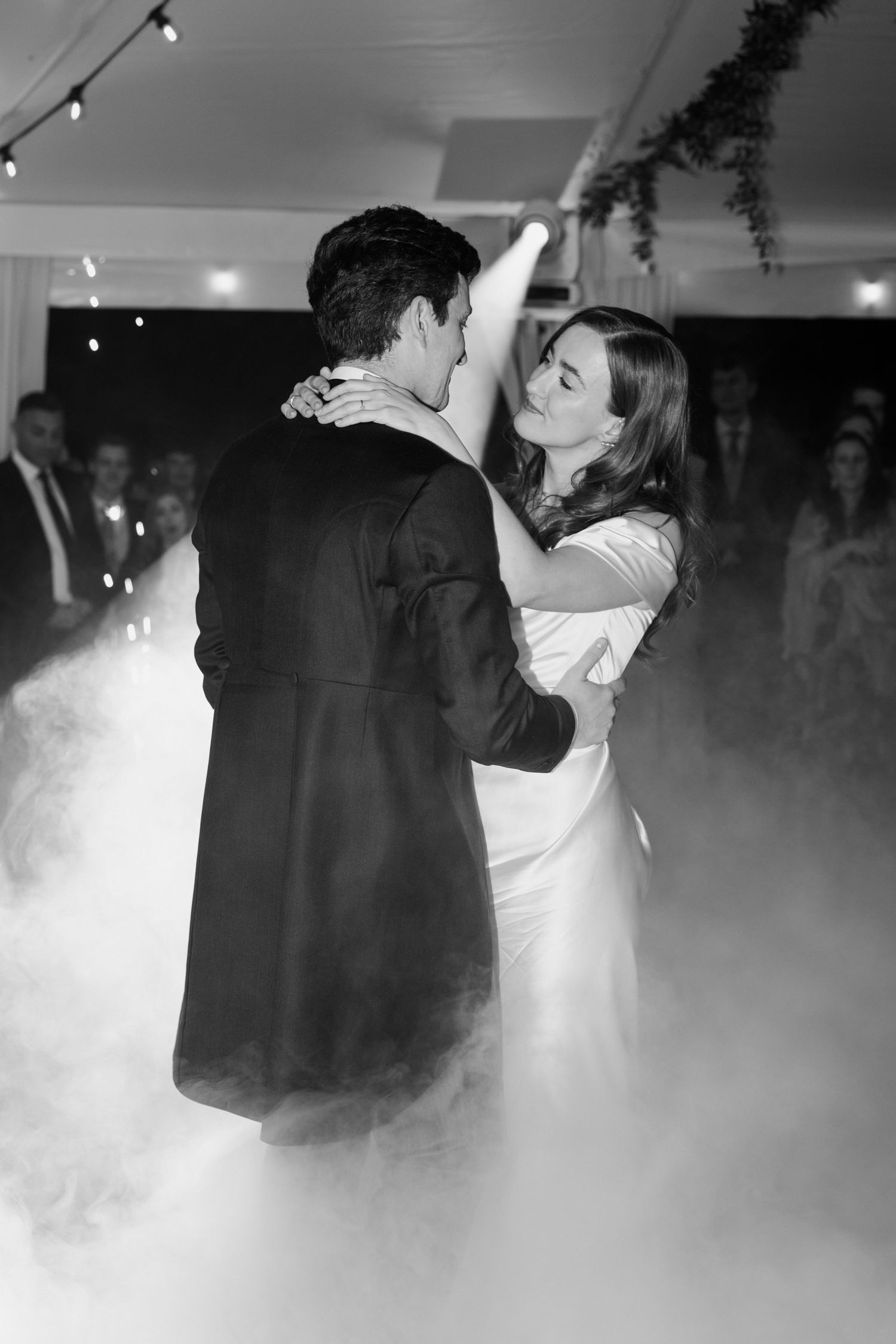 Romantic first dance at wedding reception with fog machine creating dreamy atmosphere on dance floor.