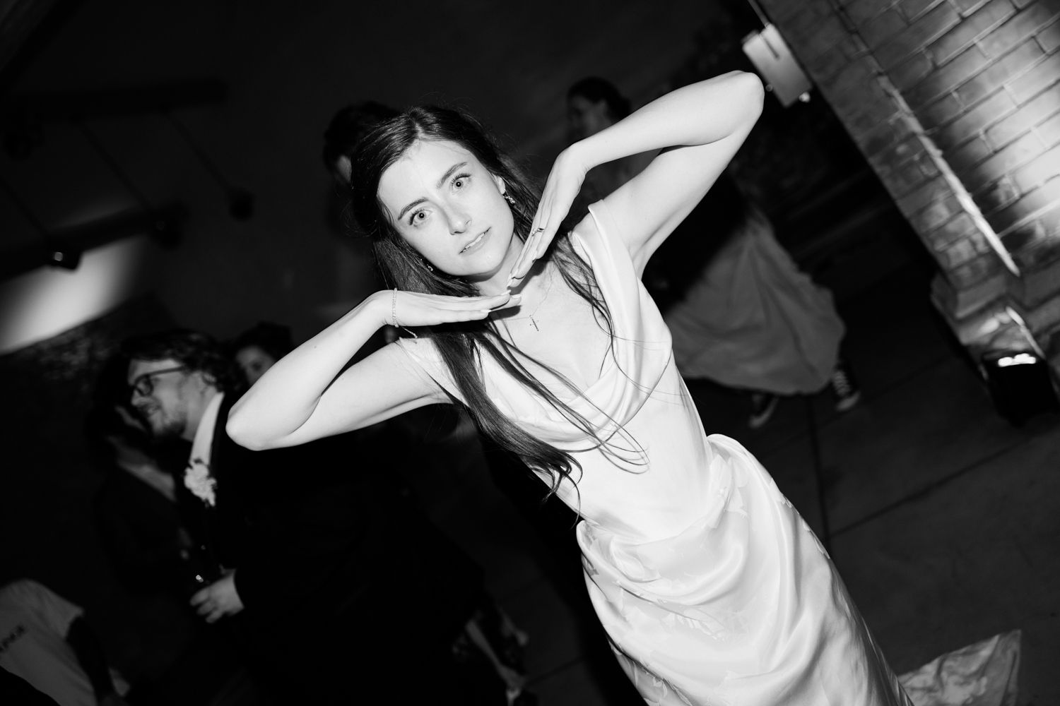 A group of people dancing and having fun at what appears to be a wedding reception or party setting.