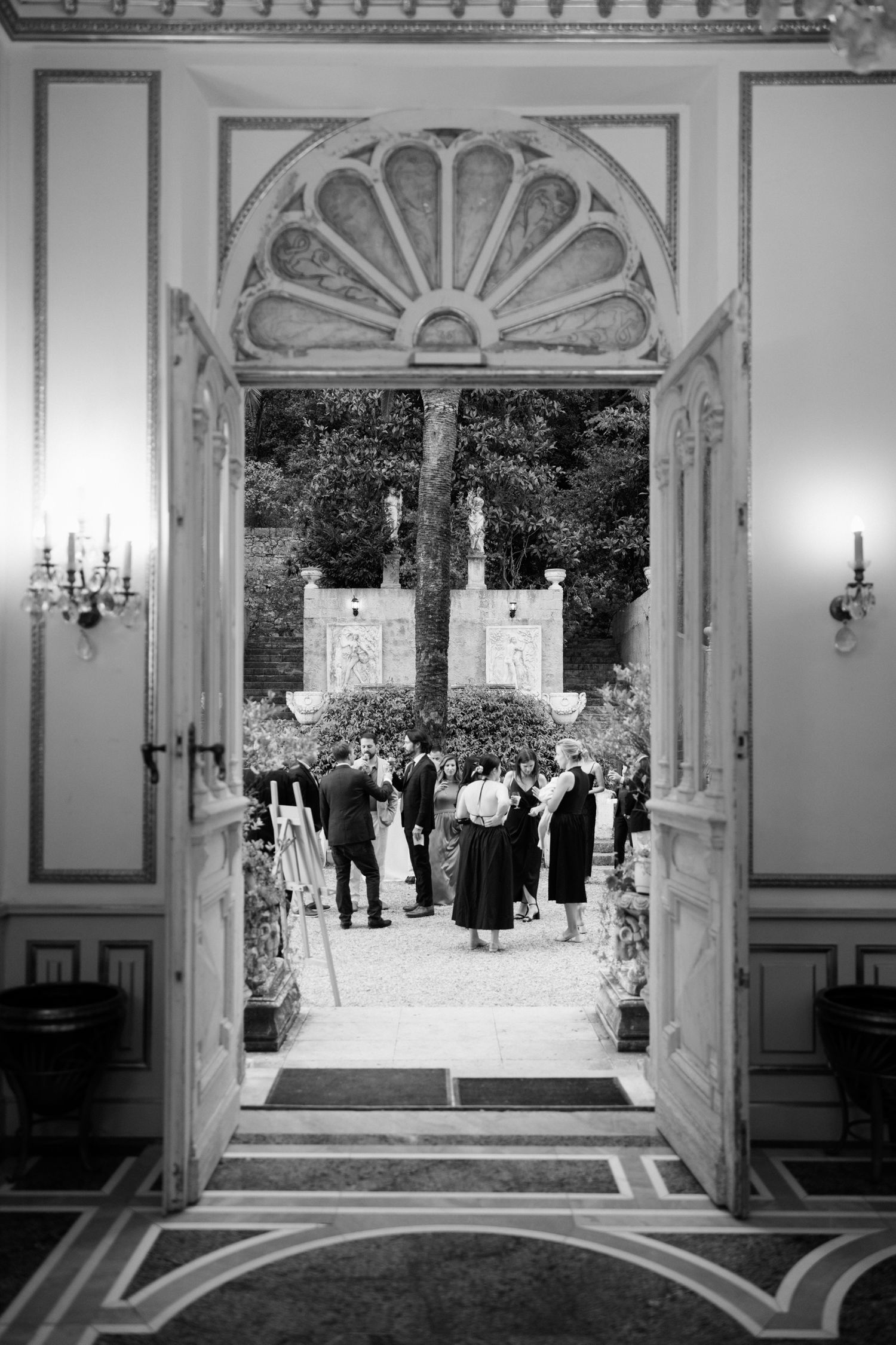 Black and white panoramic view of a grand ballroom interior with ornate architectural details and decorative moldings.