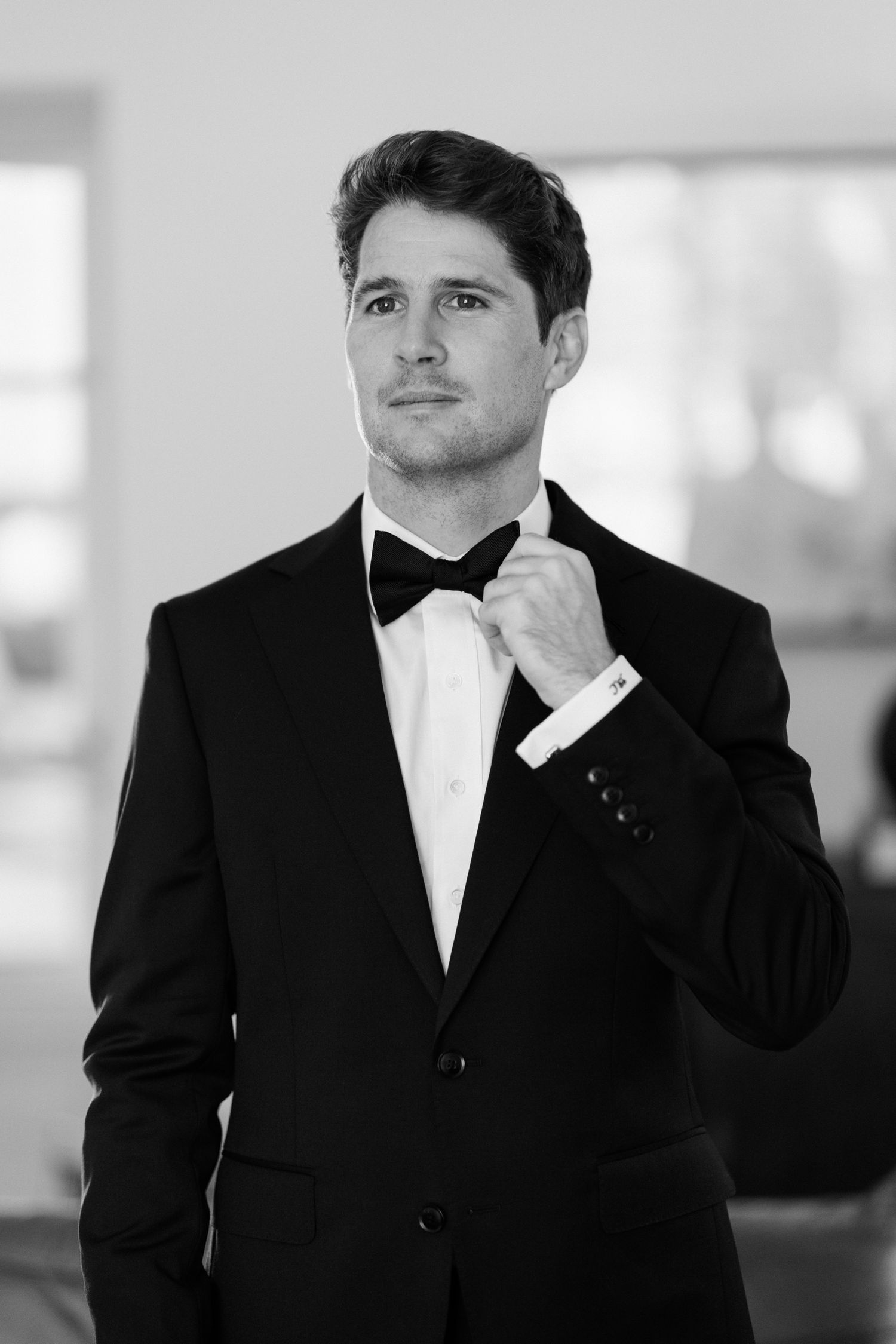 Black and white photo series showing formal portraits of a person in a classic tuxedo with bow tie. Editorial wedding photographer france