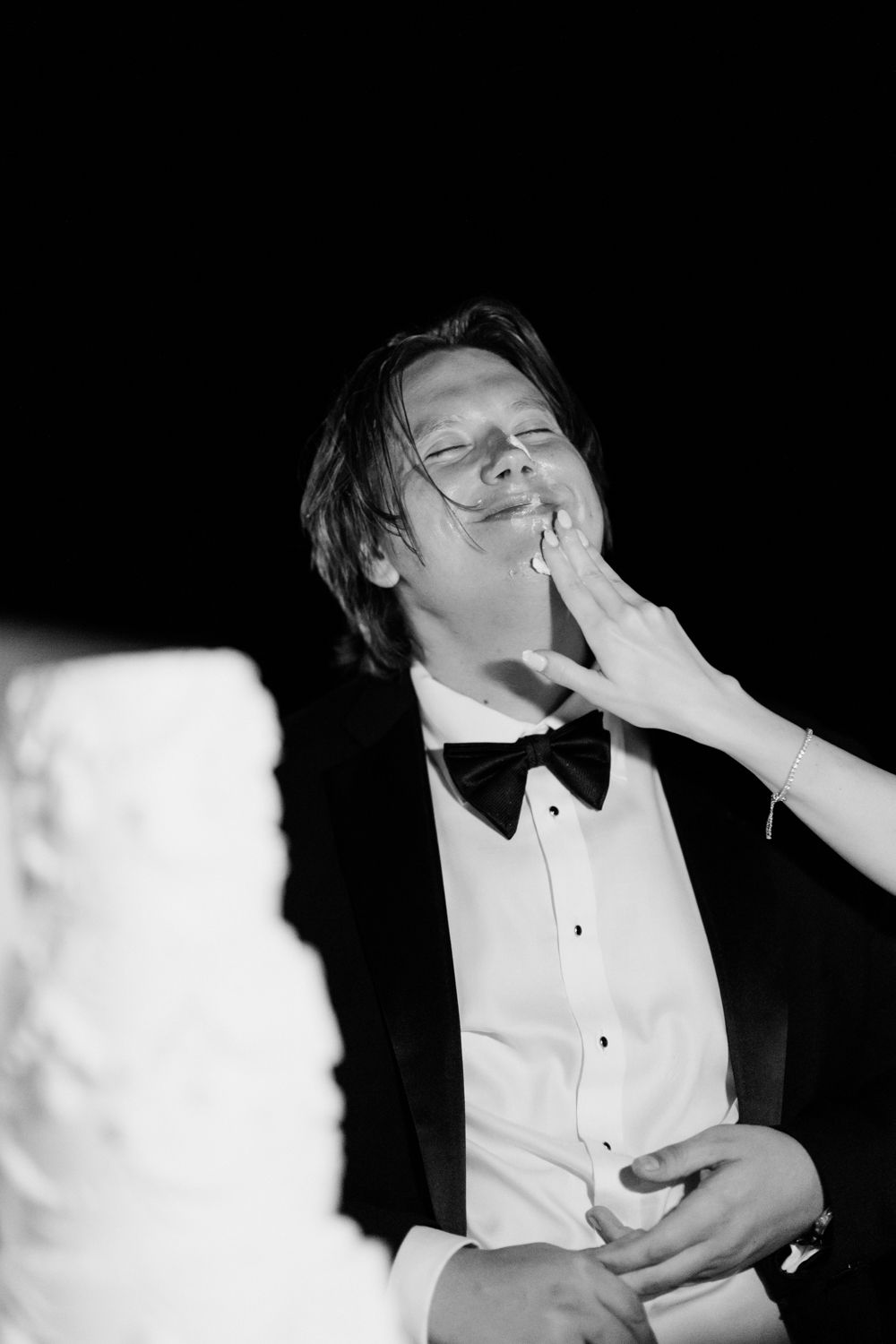A person in a tuxedo appears to be dramatically struck across the face in a sequence of black and white photos.