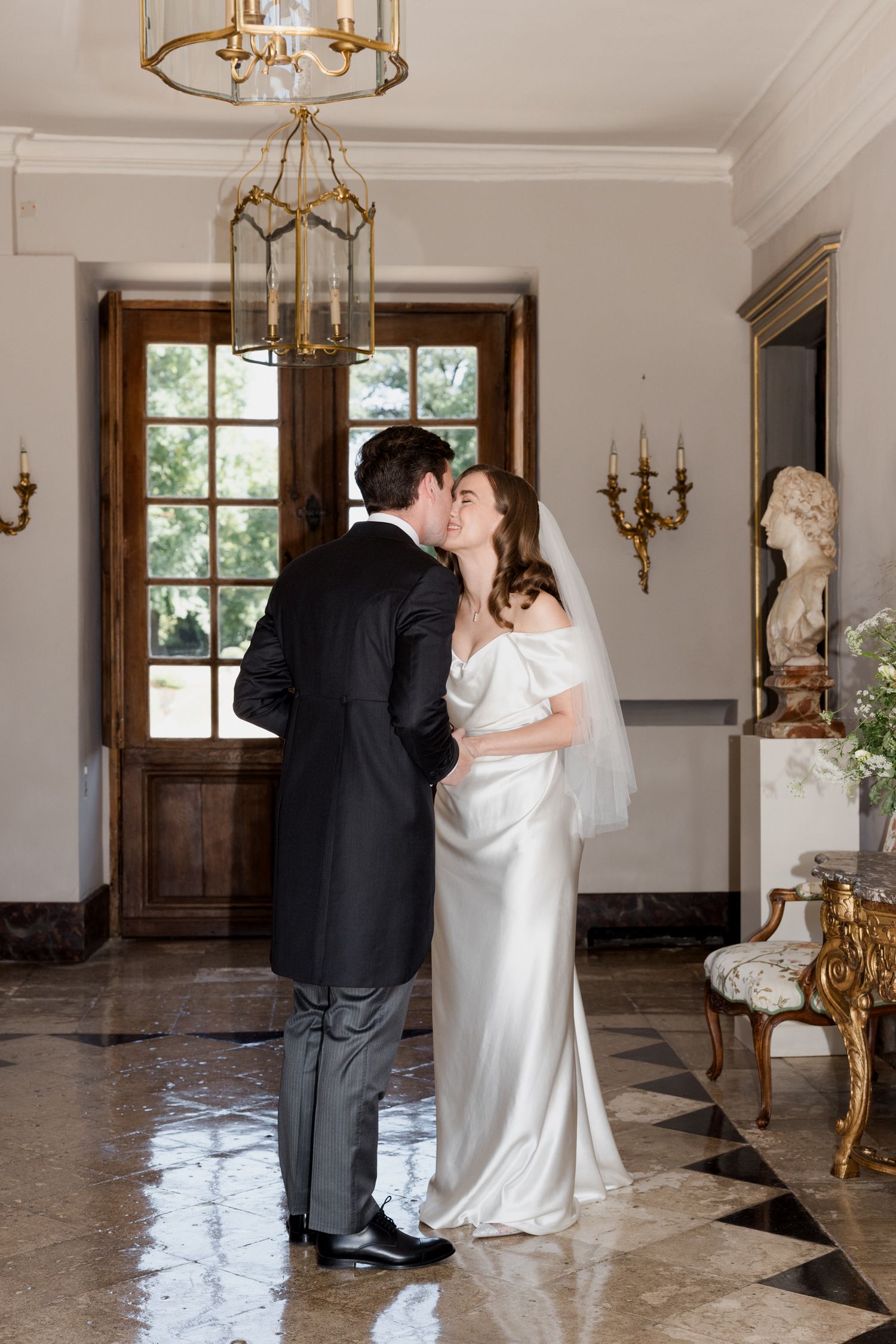 A romantic first dance sequence between newlyweds in an elegant ballroom with gold chandeliers and marble floors.