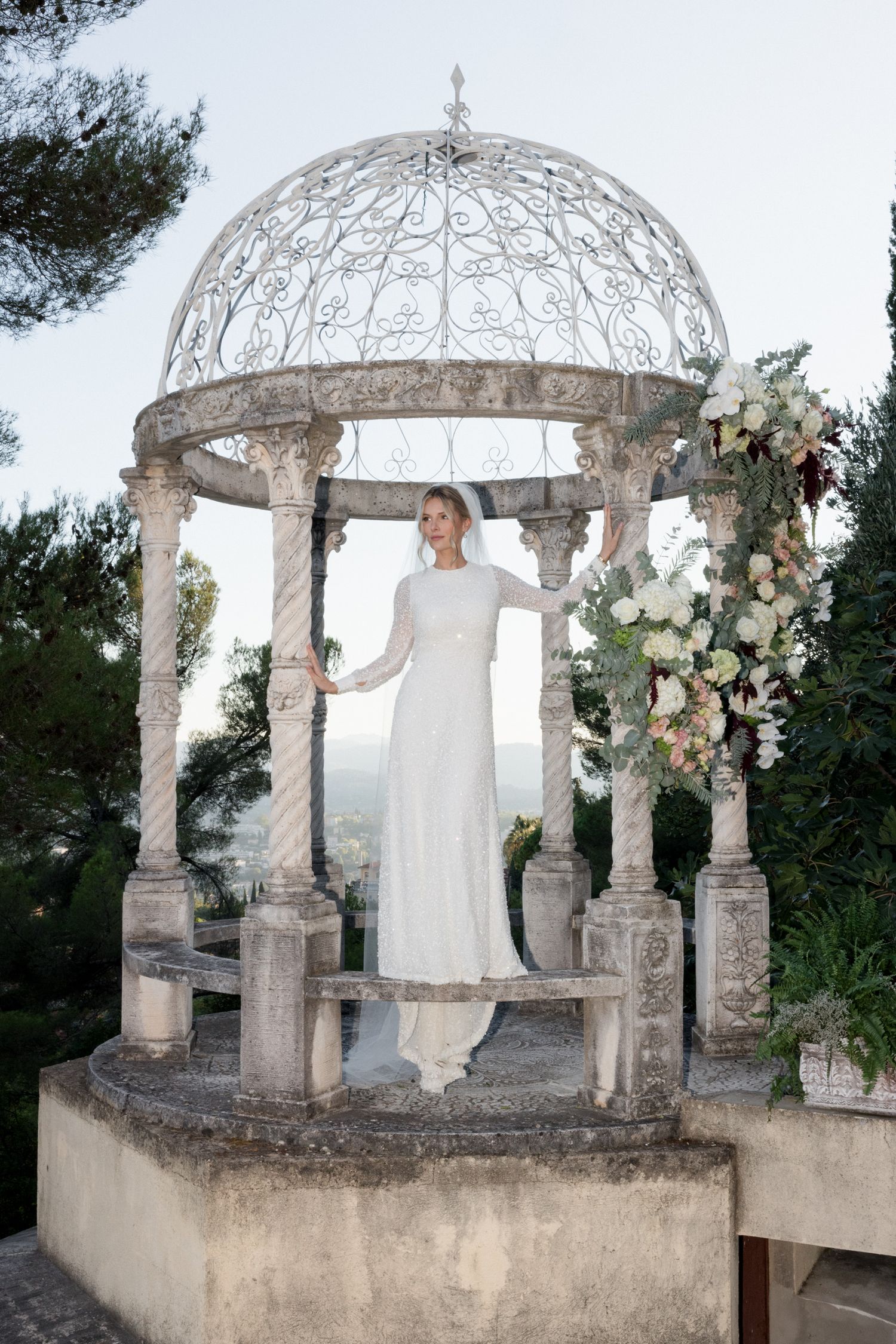 A romantic stone gazebo with ornate domed roof decorated with floral arrangements for a wedding ceremony. Photographe mariage france