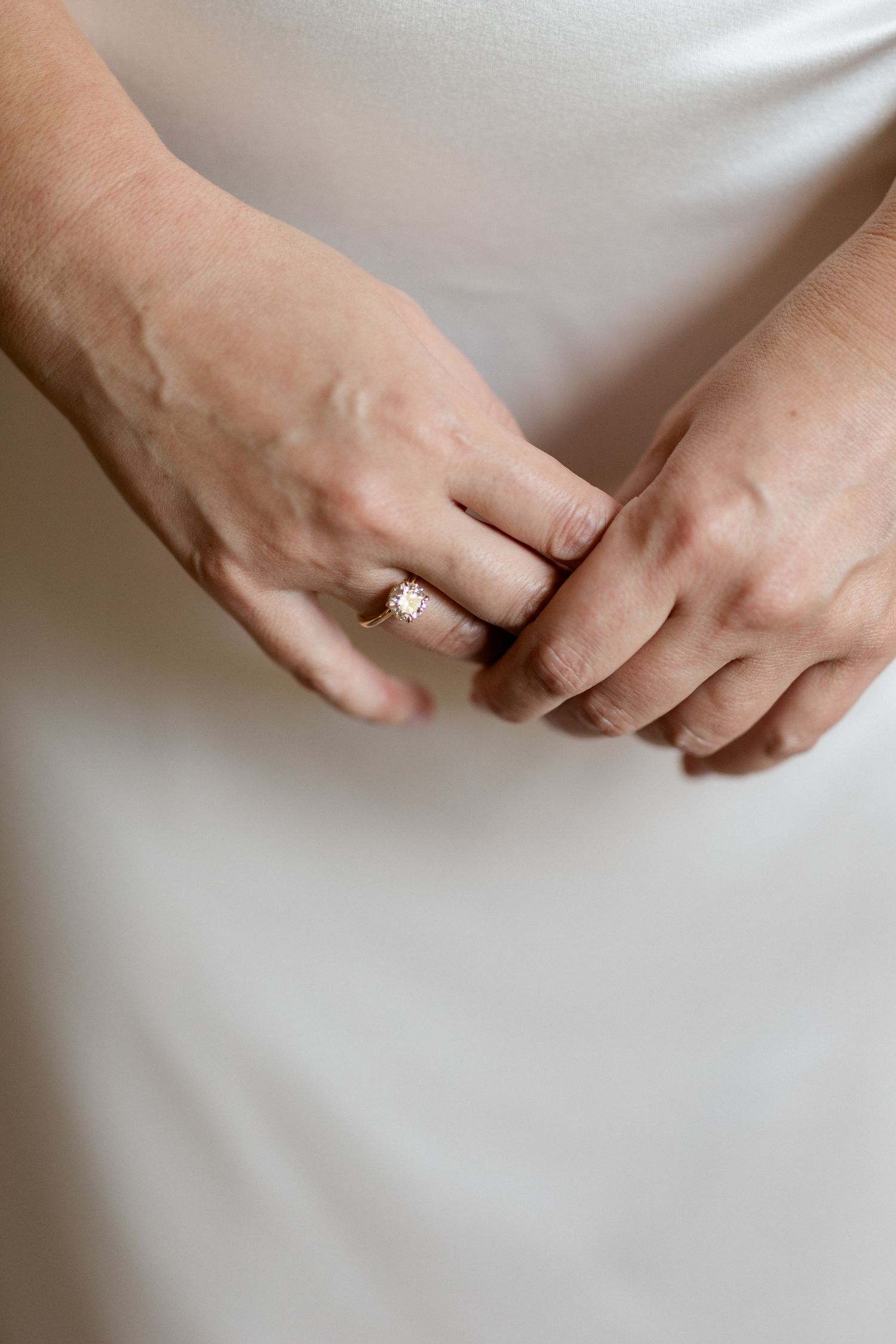 A series of close-up shots showing hands wearing wedding rings against a white background. Editorial wedding photographer france