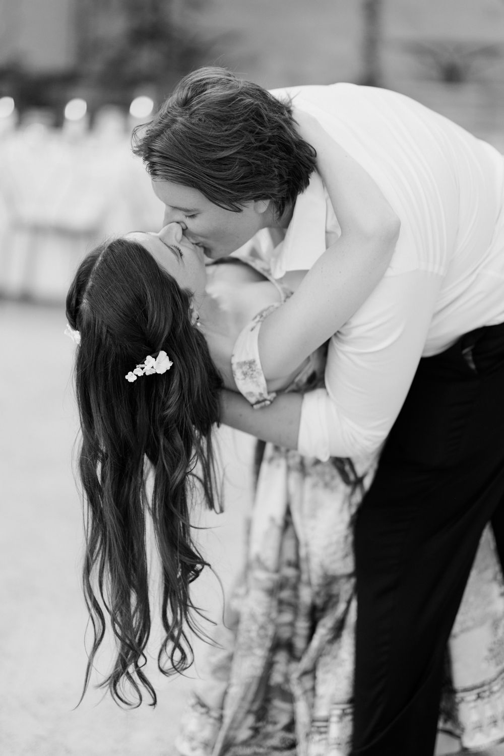 A romantic black and white photograph captures an intimate moment between a couple on their wedding day.