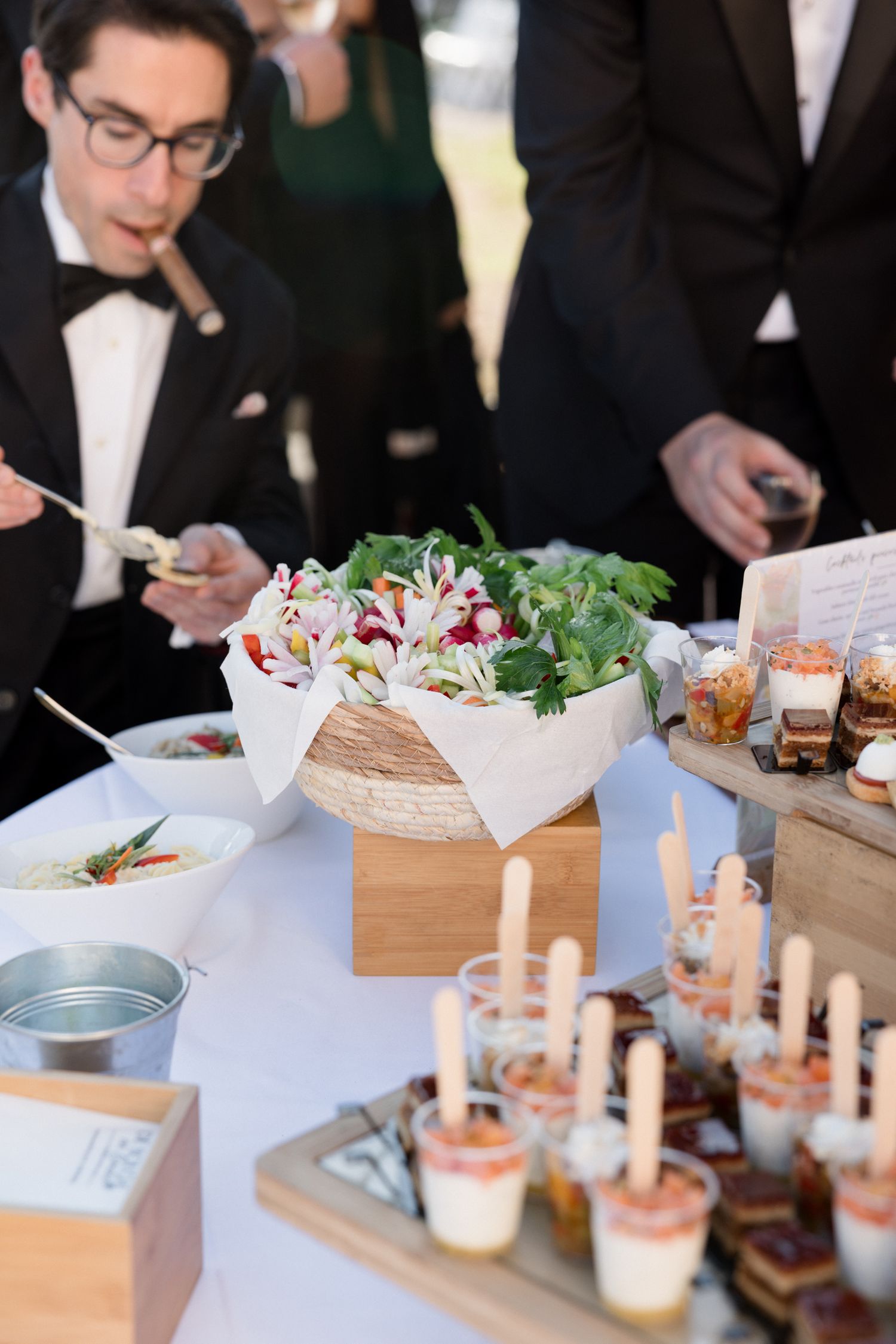 Guests gather around an elegant table with appetizers and candles at an upscale dining event.