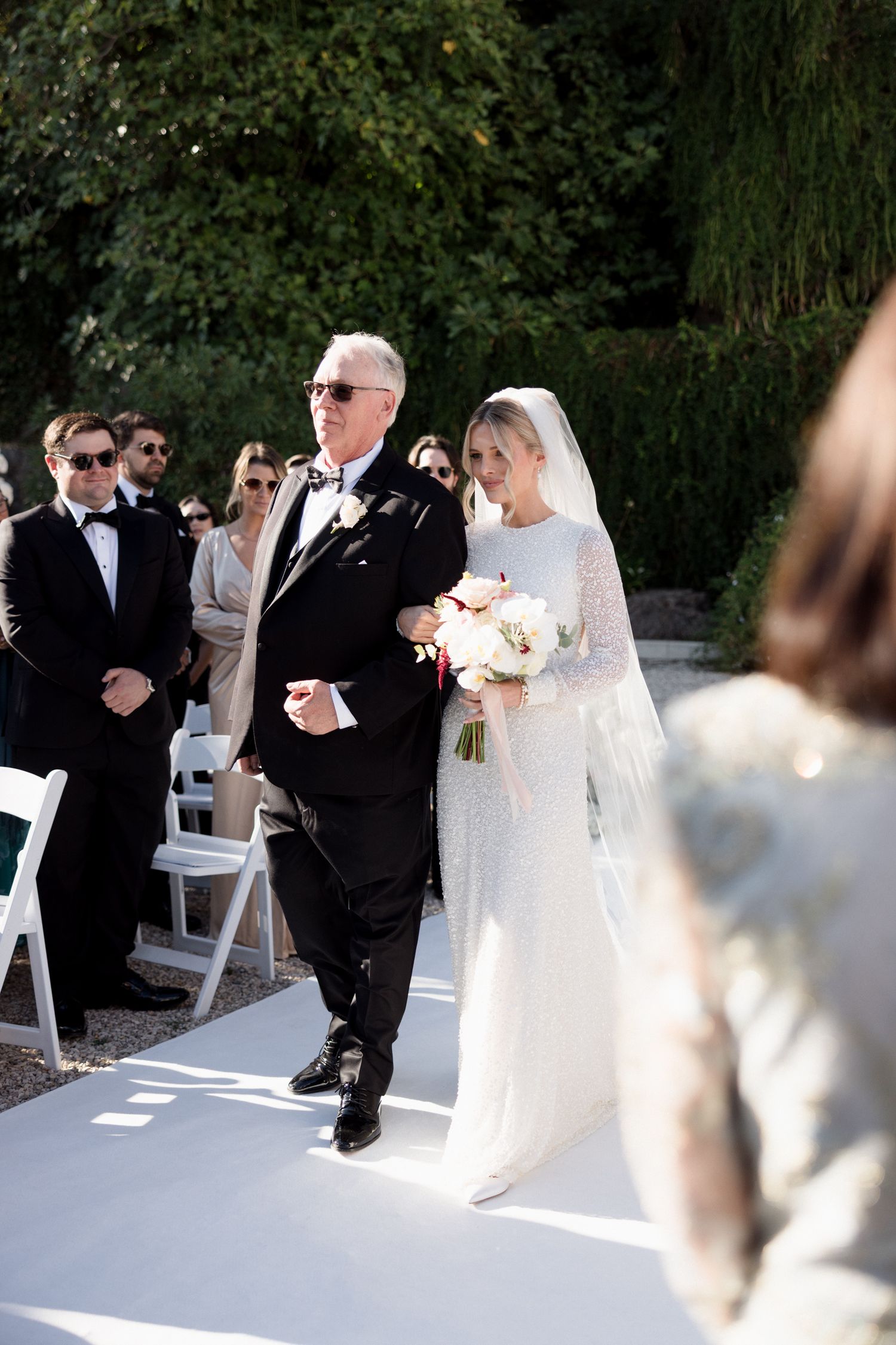 A wedding ceremony sequence showing a bride in white dress and groom in black suit exchanging vows outdoors.