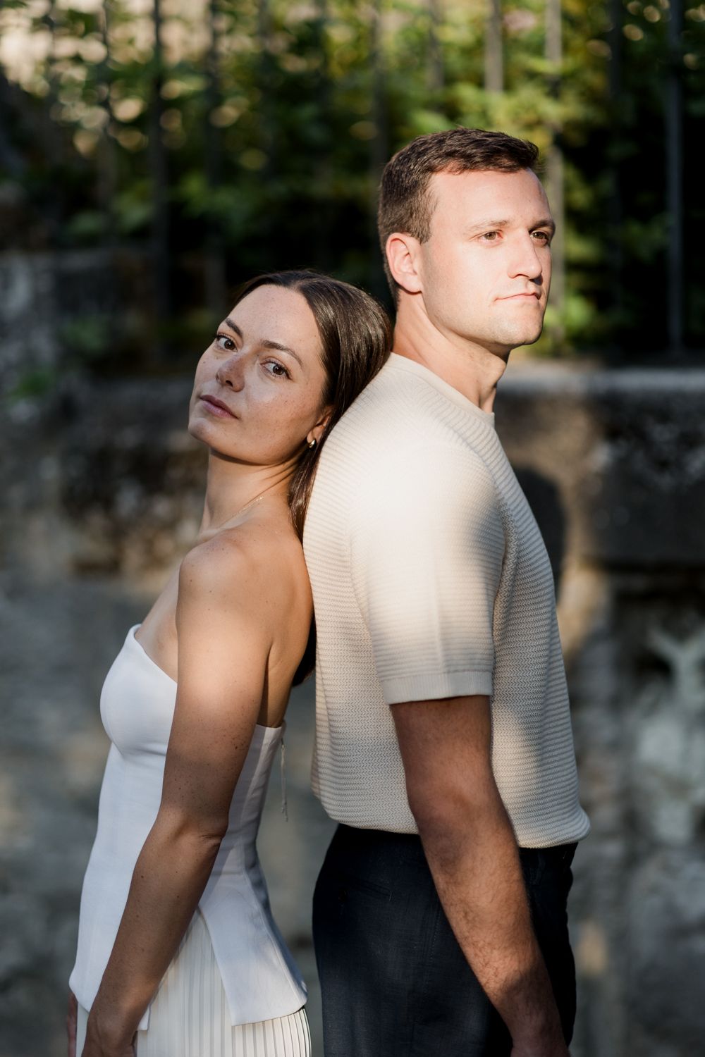 A couple in contrasting white and black outfits pose artistically in a creative outdoor portrait series. Seance couple Tours