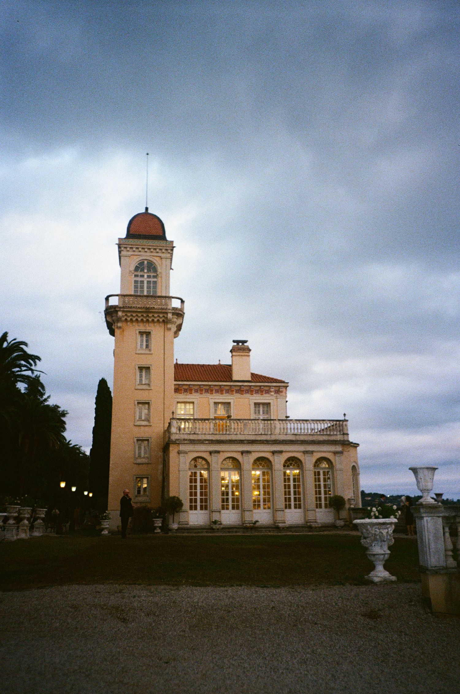 Historic lighthouse building with Mediterranean architectural style sits atop a hill under moody cloudy skies. destination wedding france