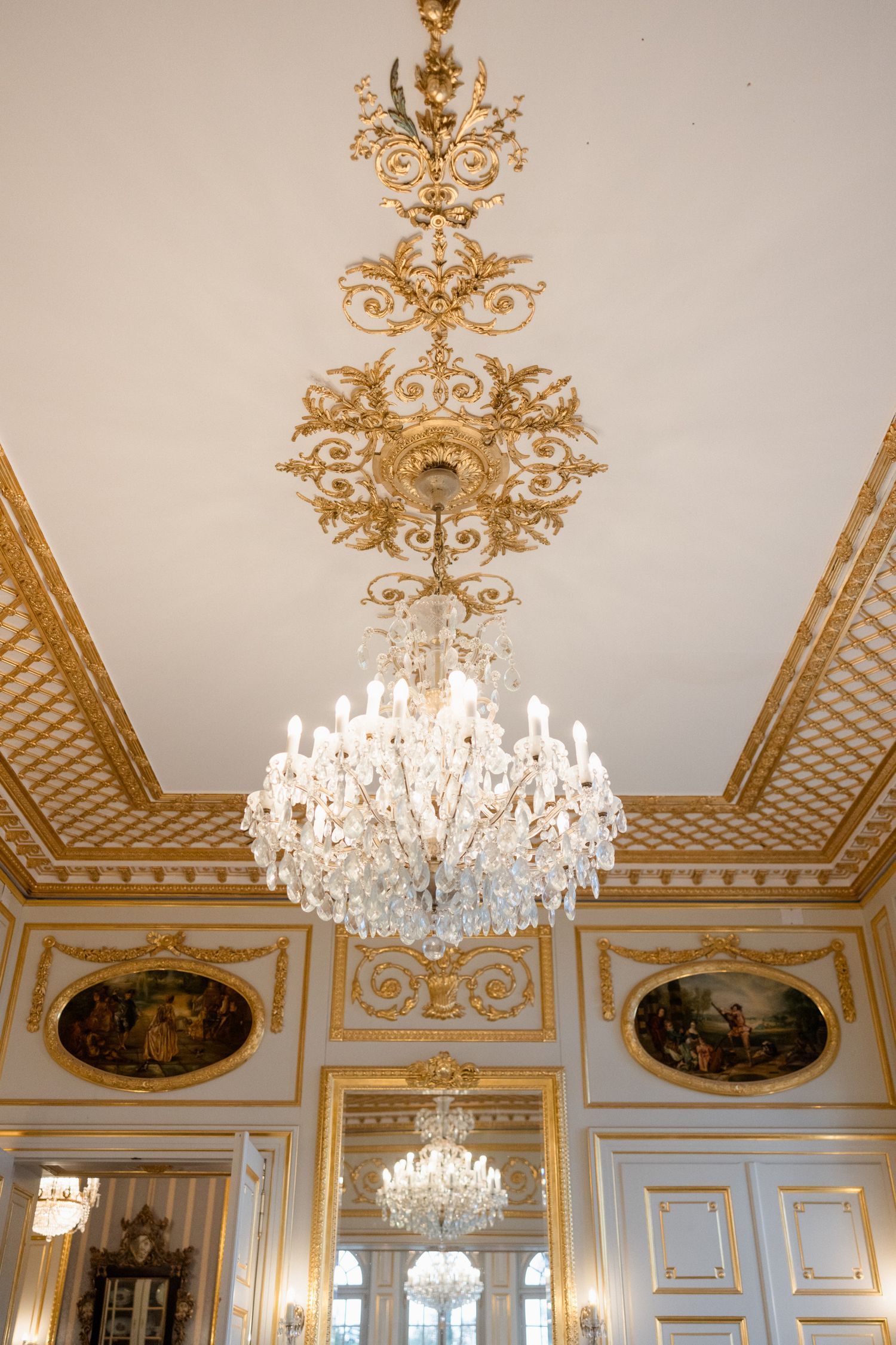 Ornate baroque palace interior with crystal chandeliers and gilded ceiling moldings in a row of connected rooms. Mariage grasse