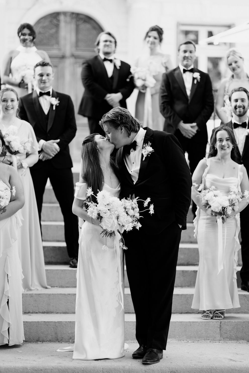 Black and white wedding party processional with bridesmaids in light dresses and groomsmen in tuxedos. Château des 3 Fontaines wedding