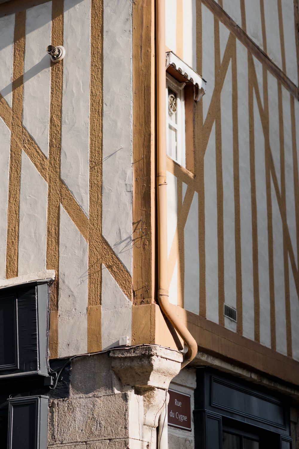 Half-timbered medieval building facade with exposed wooden beams and white plaster walls in historic architectural style.
