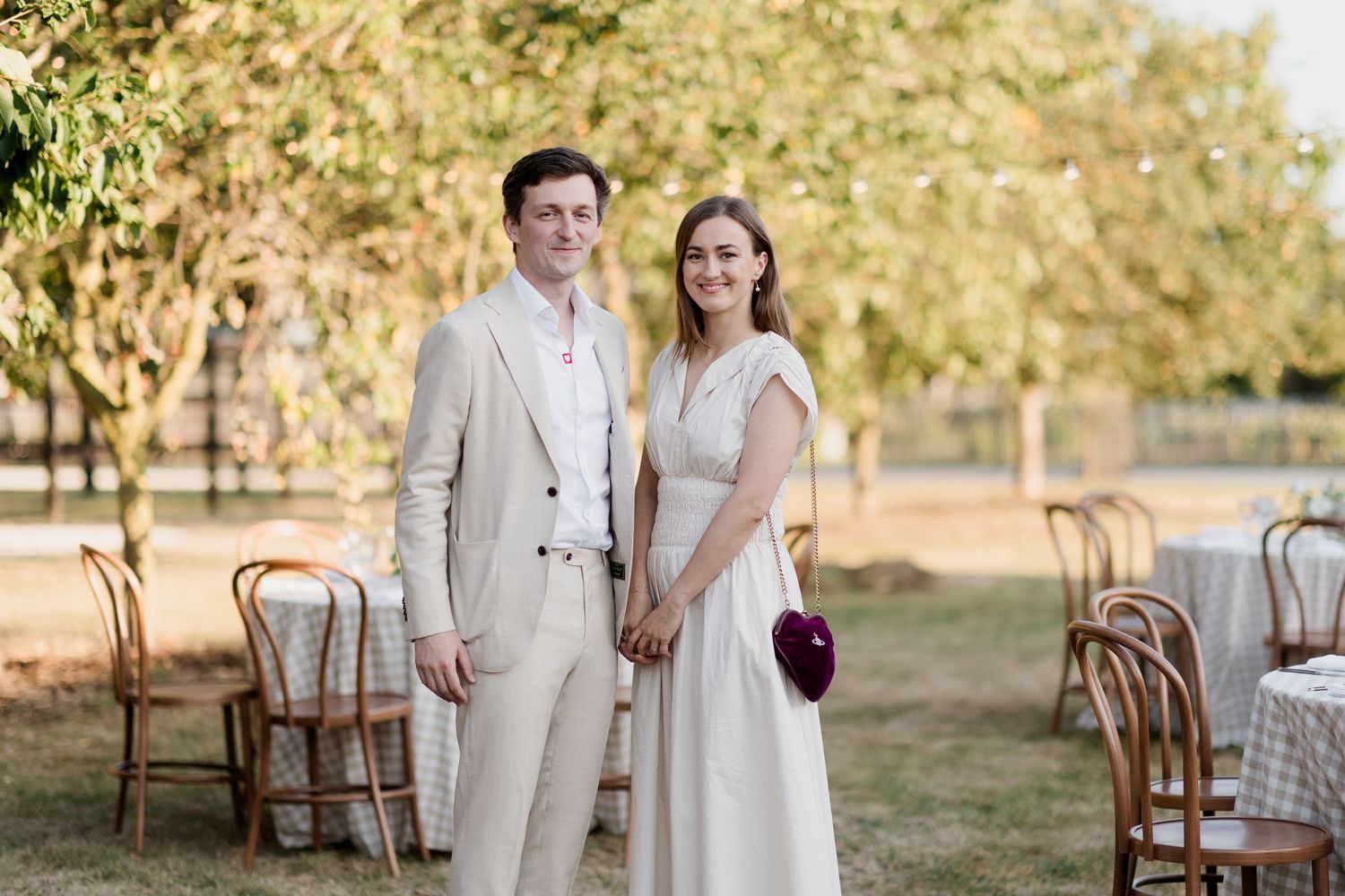 Couple in light-colored attire poses together during outdoor autumn wedding photoshoot at golden hour. Loire valley wedding photographer