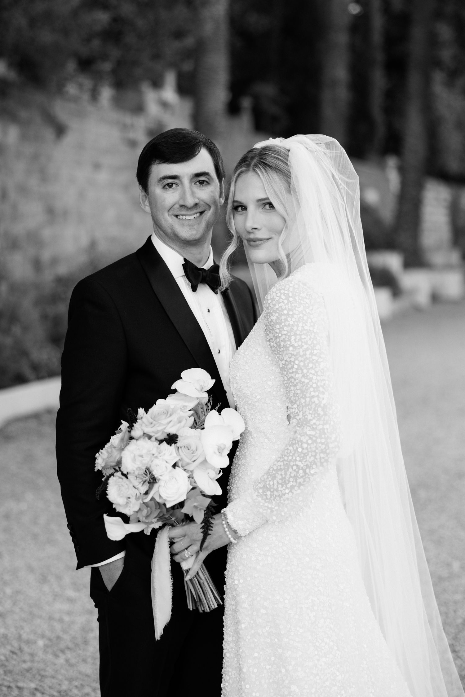 A bride and groom share a romantic moment in black and white wedding photos showing different poses and angles.