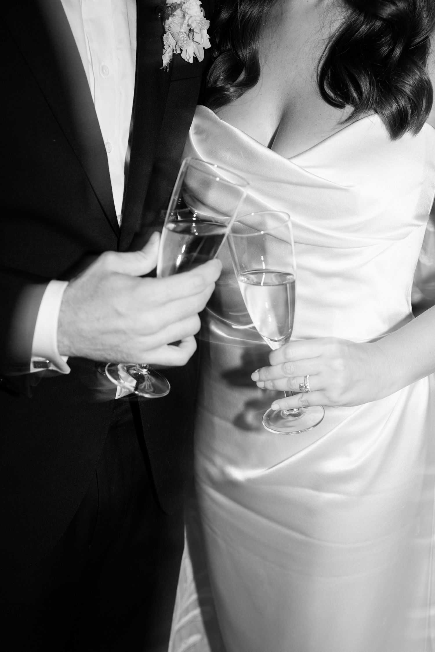 A sequence of black and white photos showing hands holding wine glasses against a white dress.