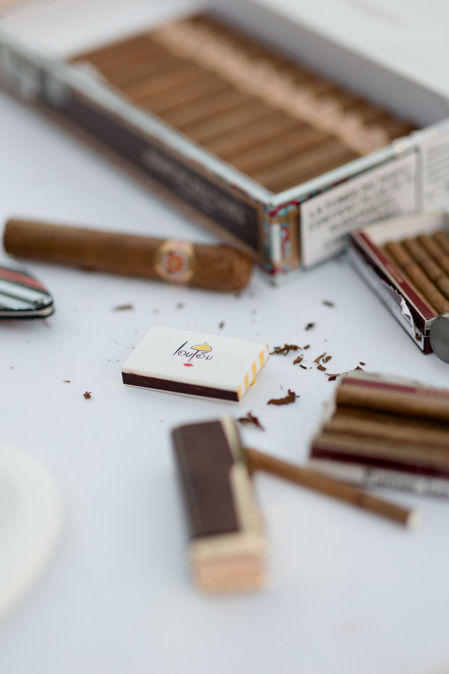 Close-up view of broken chocolate bars scattered on white surface with selective focus on chocolate pieces.