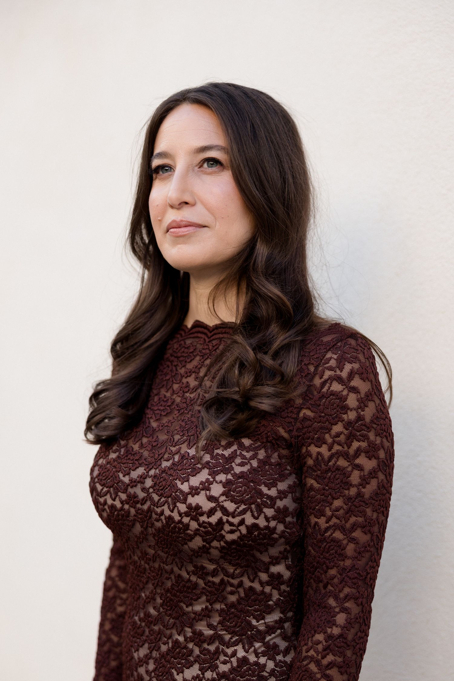 A person wearing a brown lace turtleneck poses against a white wall in a three-photo series. Engagement session France