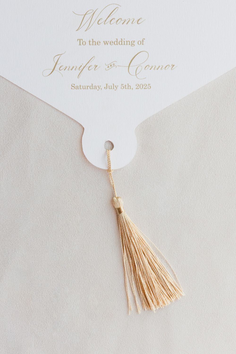 Elegant beige wedding invitation with delicate gold tassel detail shown in four close-up views.