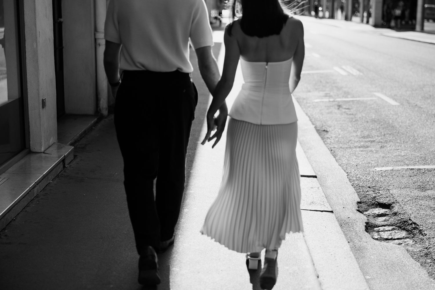 A series of black and white cropped images showing people walking on a city street, with a person in a white dress.