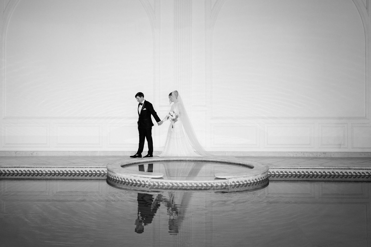 A romantic couple walks along a misty beach shoreline in black and white. editorial wedding photographer france
