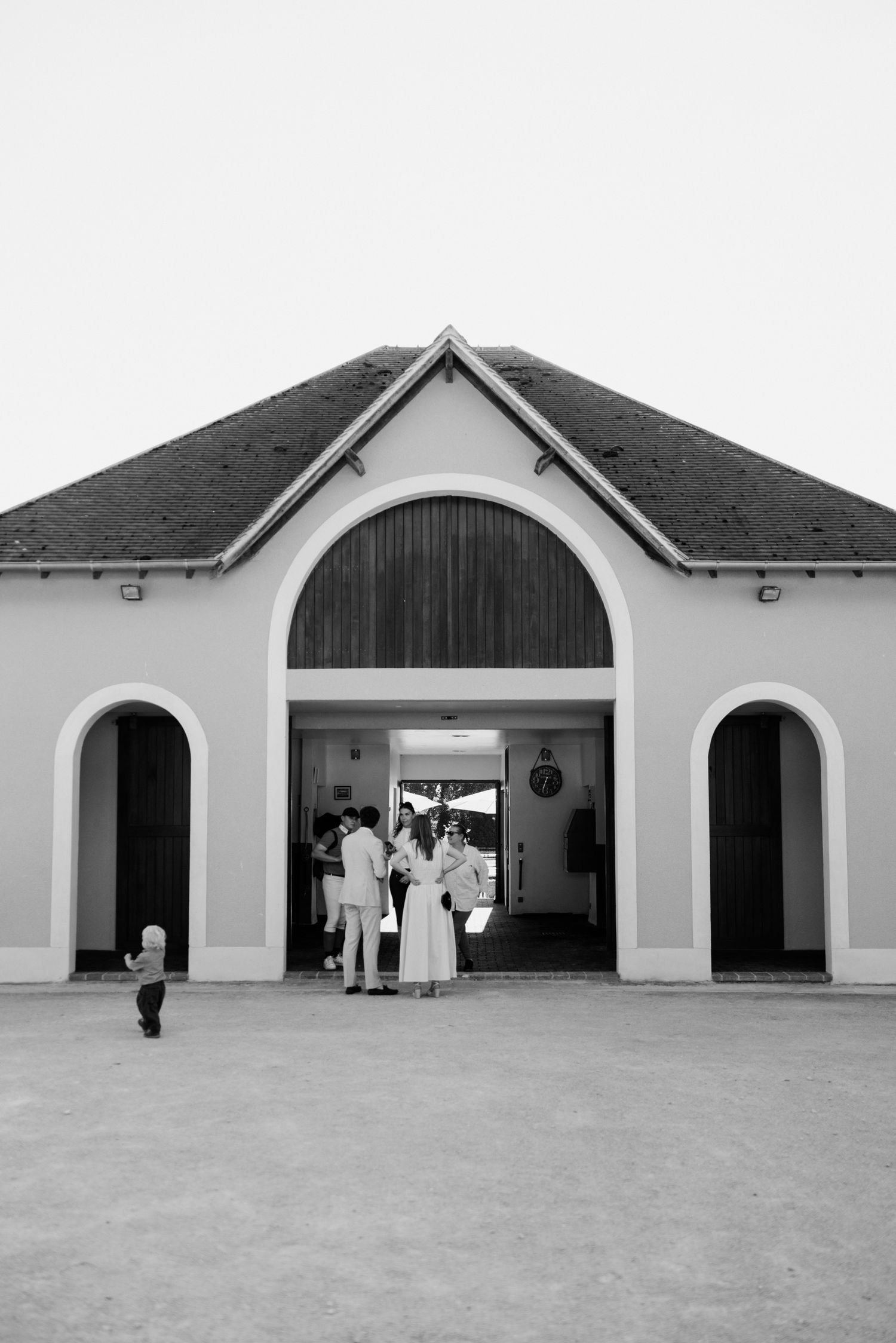 Five black and white architectural photos show arched doorways of a building with people standing in and around them.