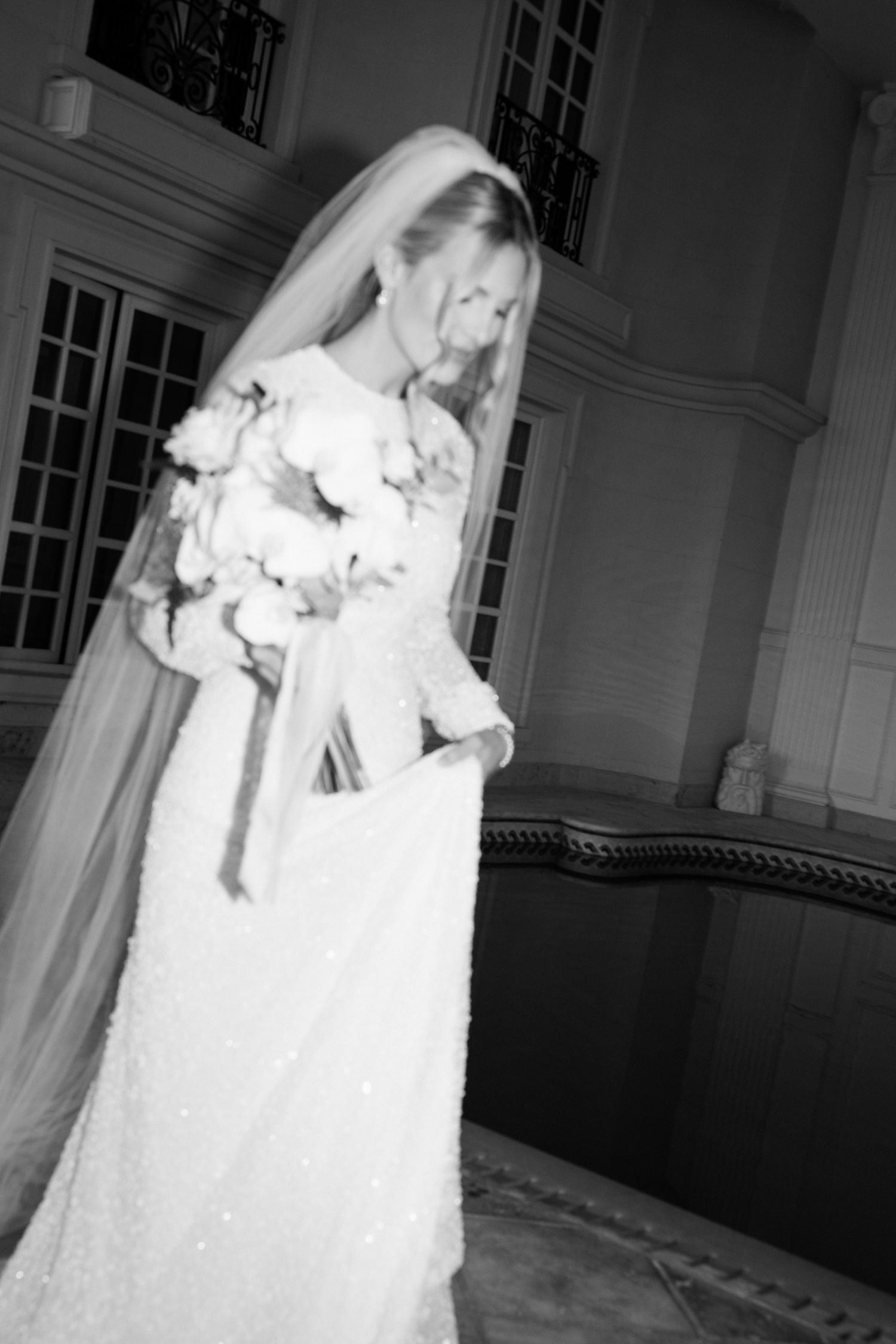 A haunting black and white photo series shows a ghostly figure in a white wedding dress moving through a dark hallway.
