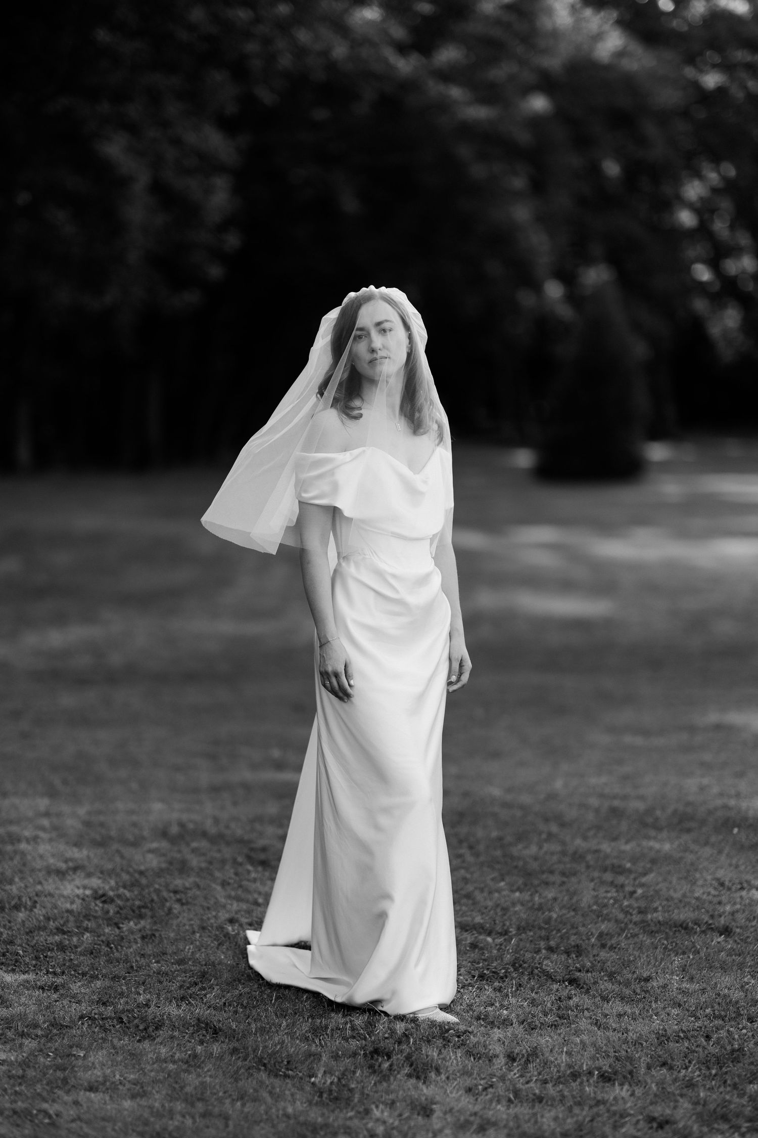 A figure in a flowing white dress spins gracefully on grass. wedding photographer france vivienne westwood bride. Wedding photographer Paris