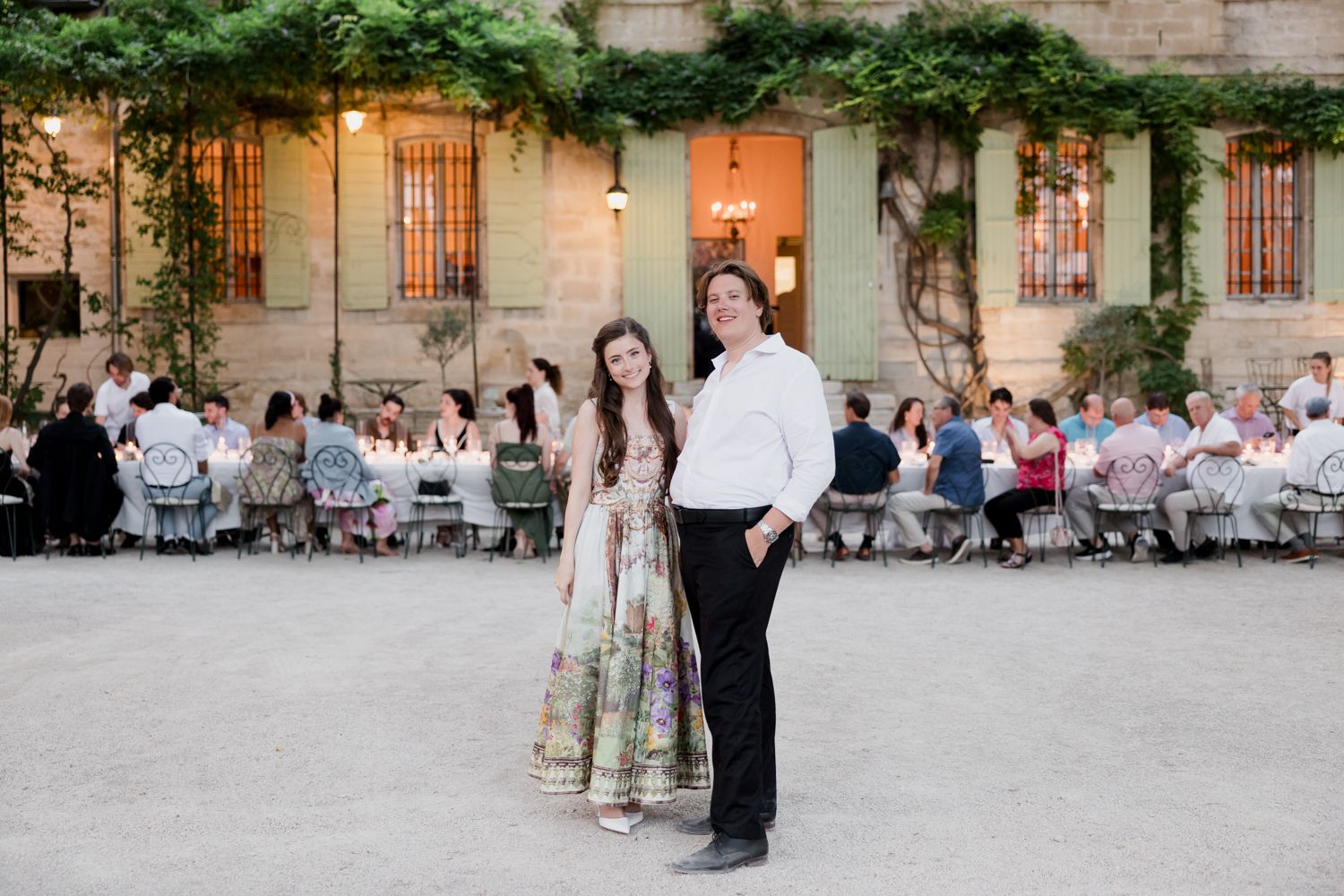 A collection of wedding photos showing formal ceremony and reception events along a historic stone building exterior at sunset. Avignon