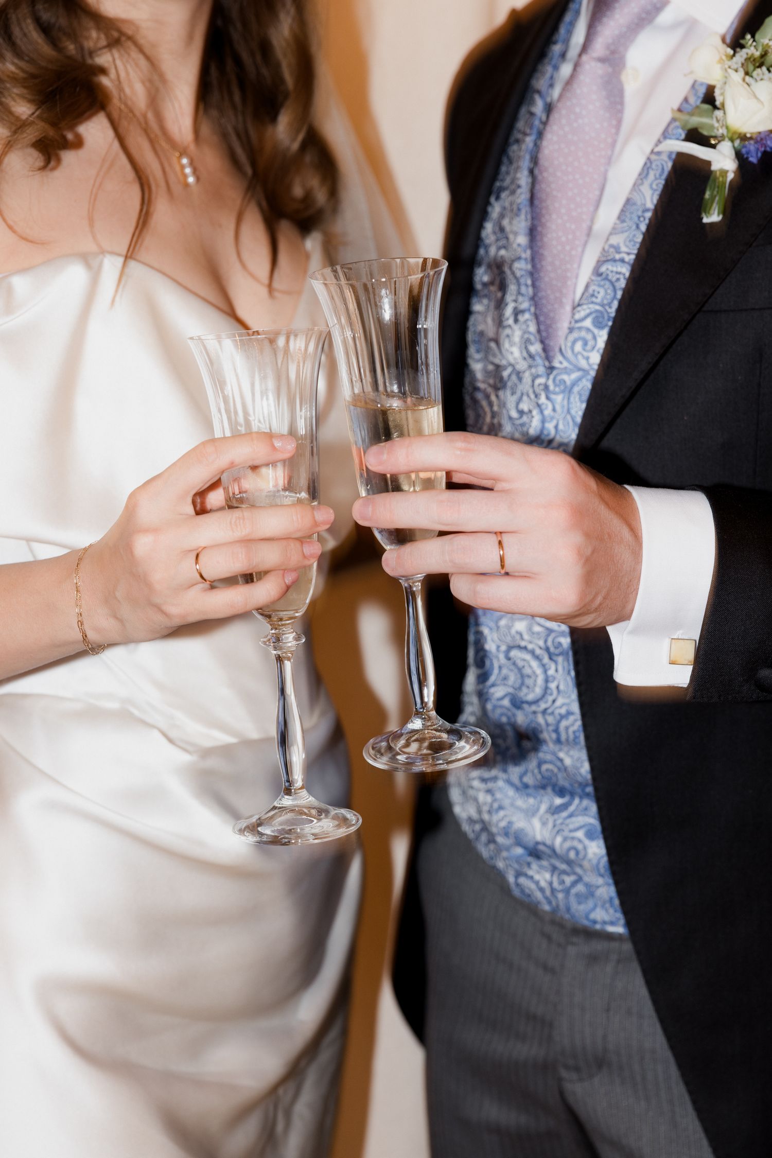 Wedding guests in formal attire clink champagne glasses during an elegant celebration toast. Paris wedding photographer