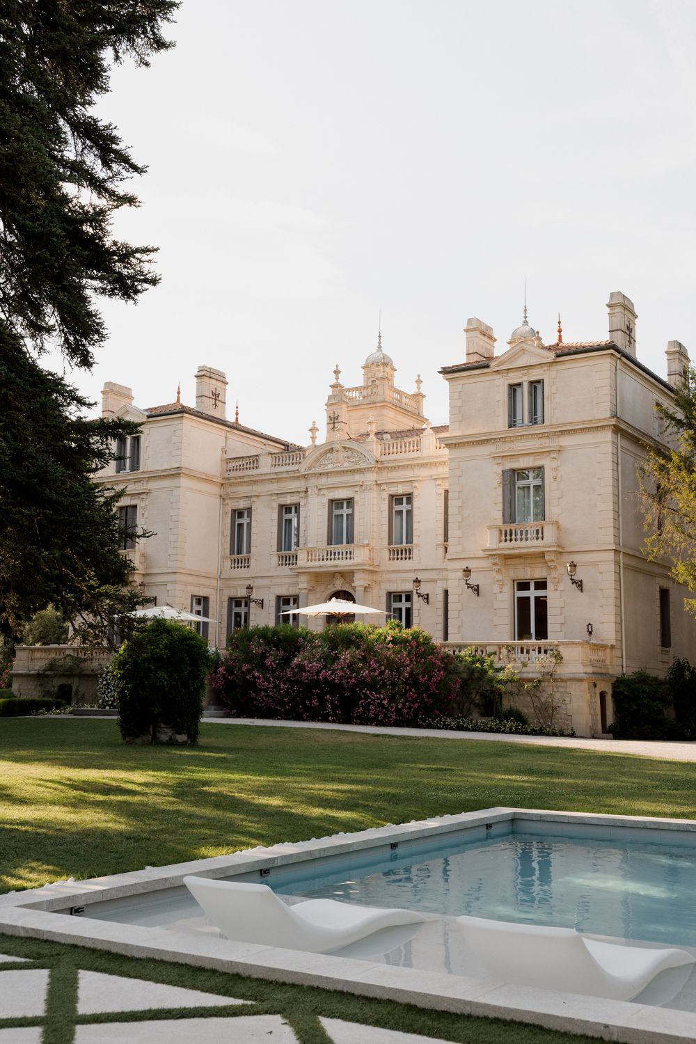 Elegant Château des 3 Fontaines in Provence with ornate architectural details and a luxurious swimming pool in the manicured grounds.