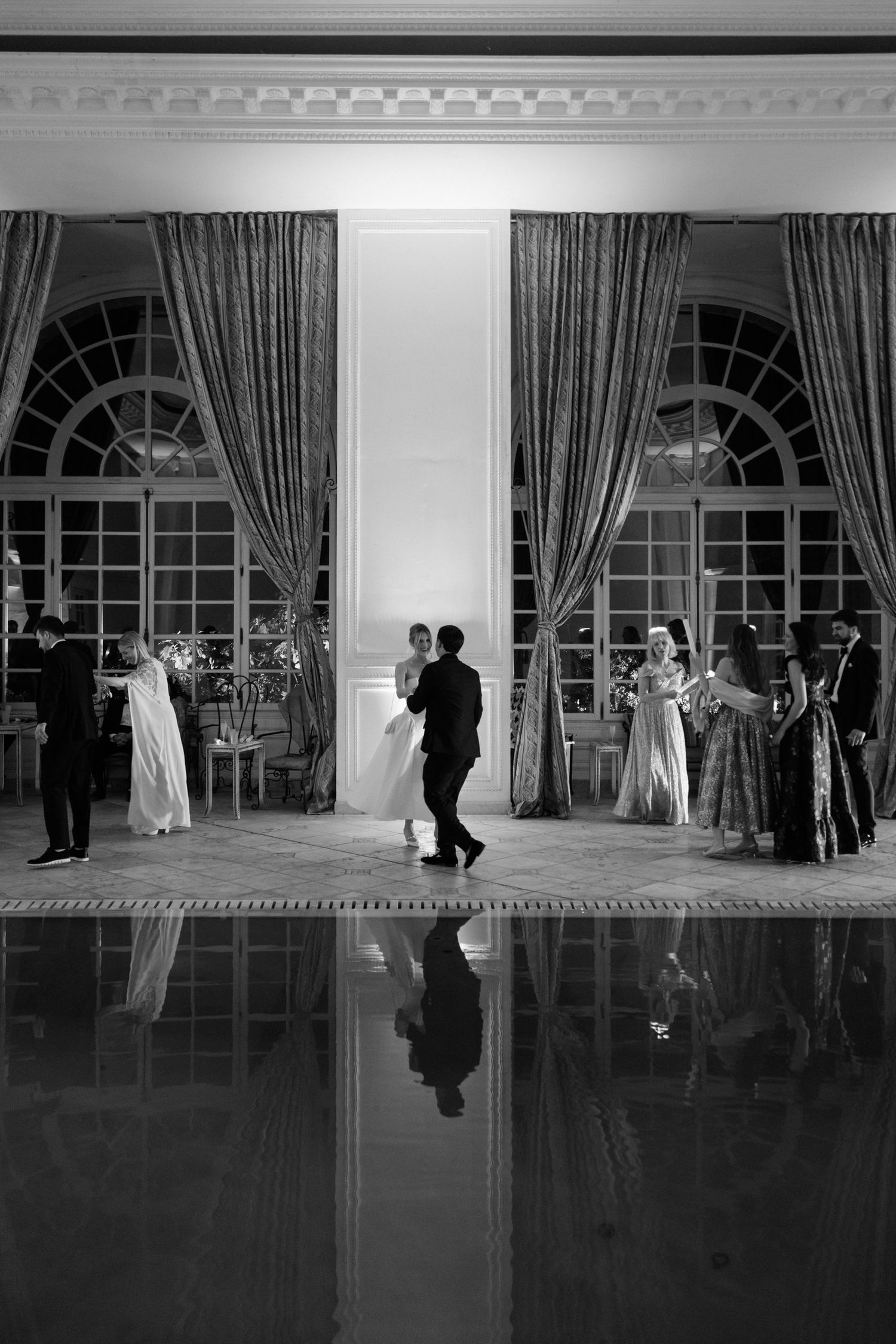 A series of black and white photos showing couples dancing in an elegant ballroom with tall windows and curtains.